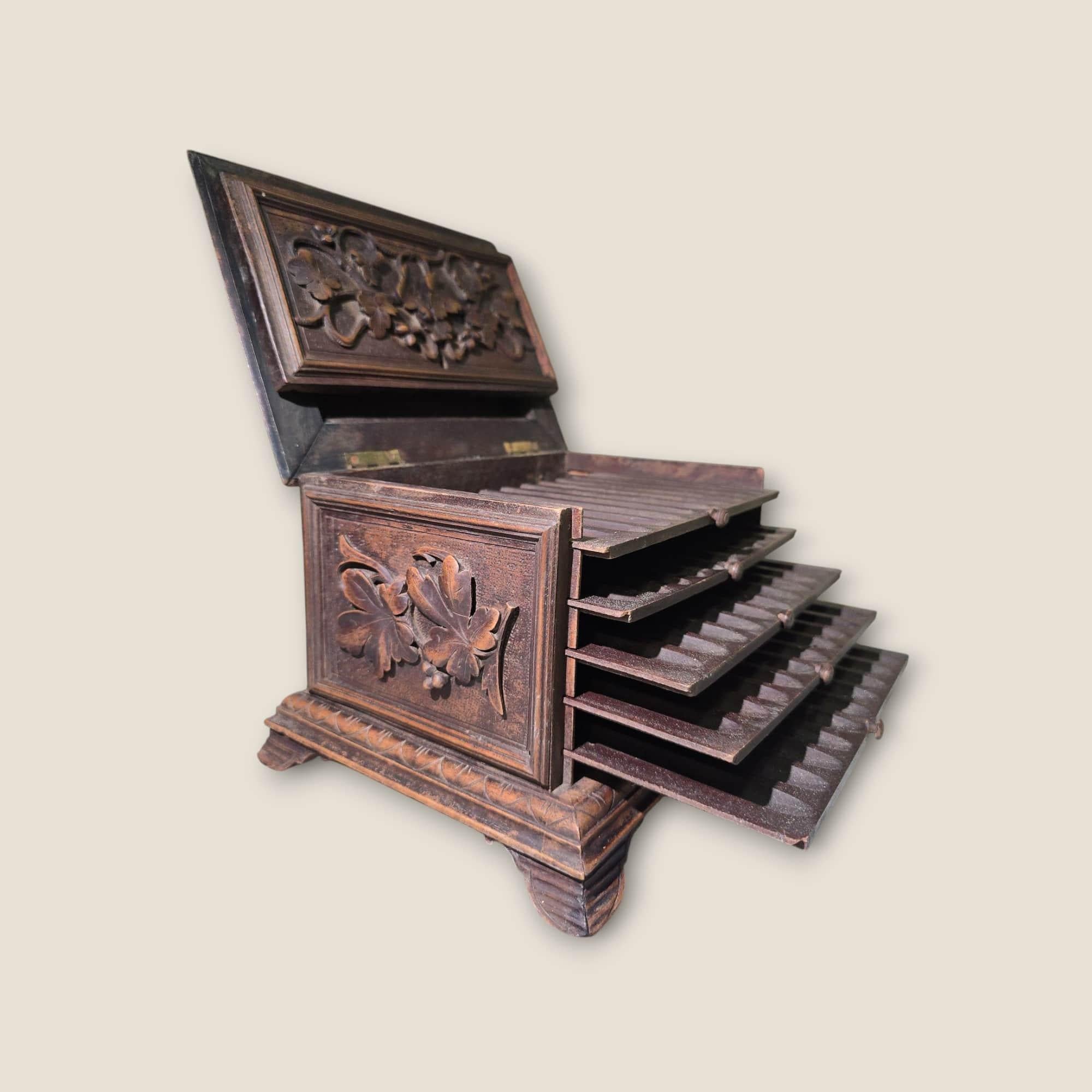 Boîte à cigares Black Forest du 19e siècle - Wood Wood sculpté à la main

Exquise boîte à cigares du XIXe siècle provenant de la Forêt-Noire, finement sculptée à la main dans le bois. Cette pièce ancienne témoigne d'un travail artisanal complexe,