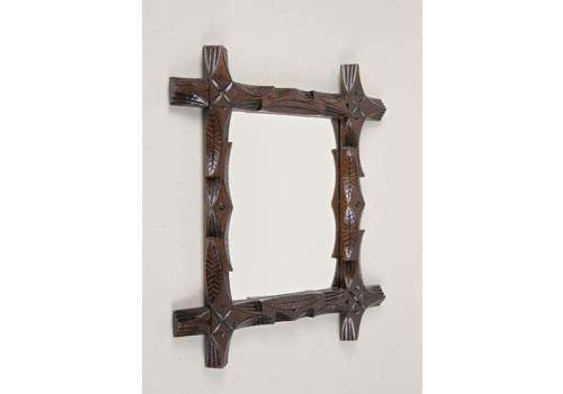 Charming, late 19th century Black Forest wall mirror out of  Austria. Artfully handcarved out of basswood around 1890, the amazing frame shows unusual, elaborately crafted leaf patterns and slightly protruding corners. In line with the rustic Black