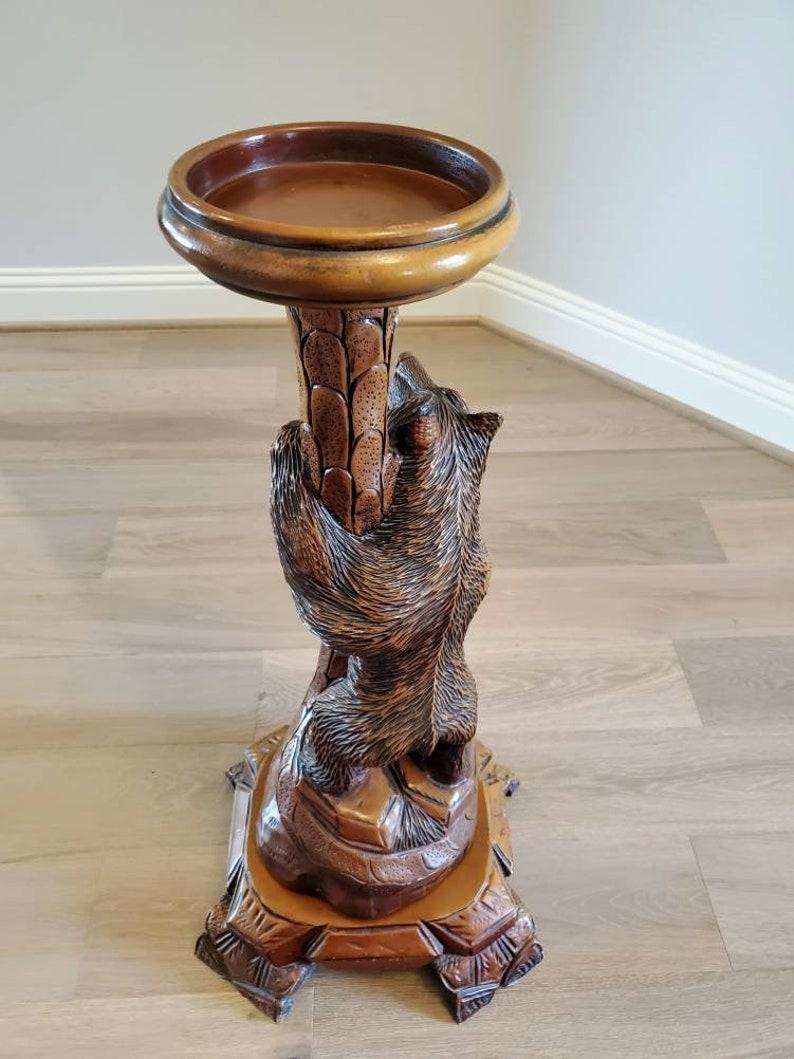 A fine quality antique Swiss Black Forest ware pedestal candle stand, exceptionally executed, hand carved and painted, naturalistic tree and large figural bear with glass eyes, open mouth with teeth exposed, finely detailed facial features and