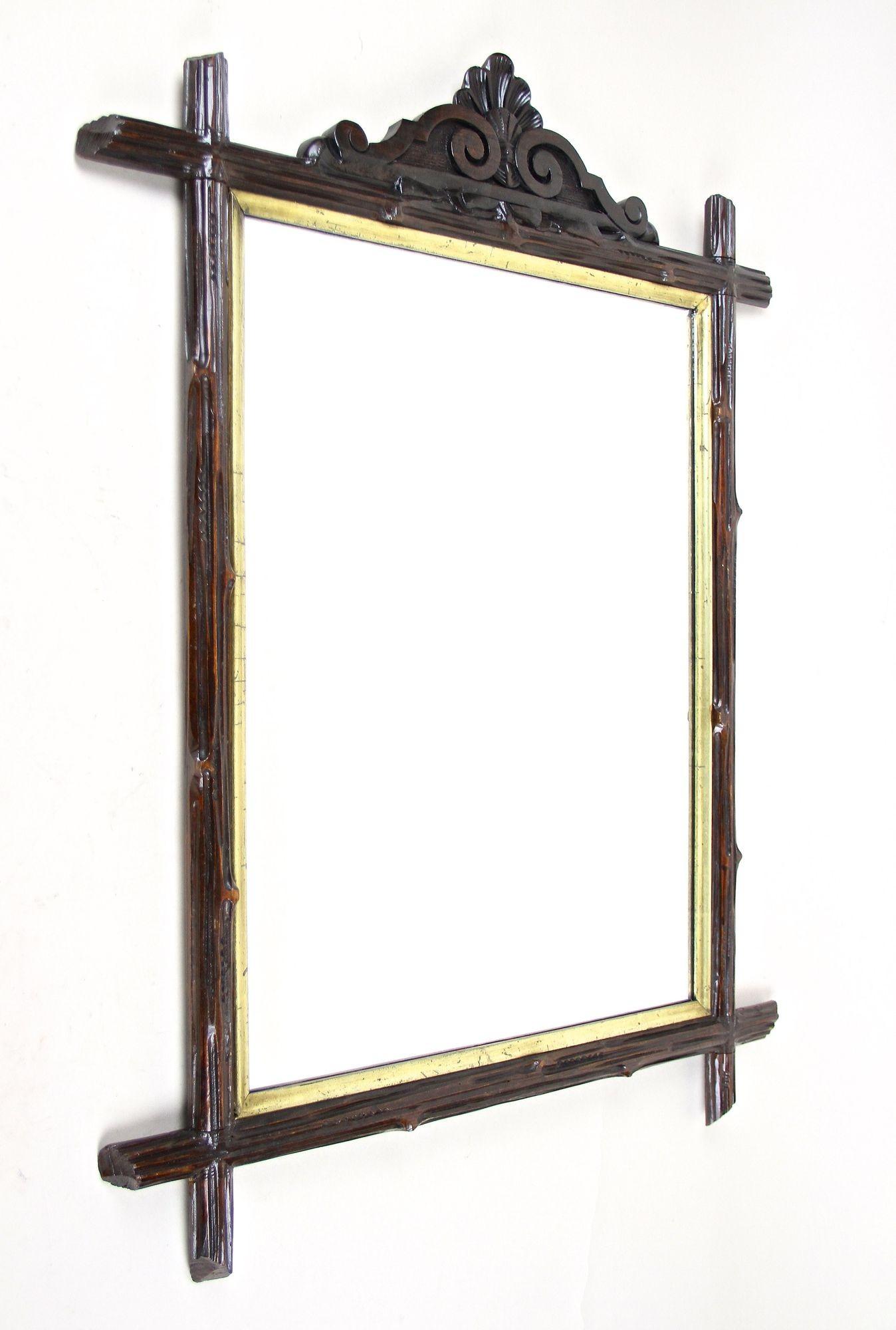 Amazing looking, rustic Black Forest mirror from the late 19th century in Austria. Elaborately handcrafted around 1880 this rural wall mirror shows an absolute unique design: a handcarved basswood frame crafted in the manner of tree branches.