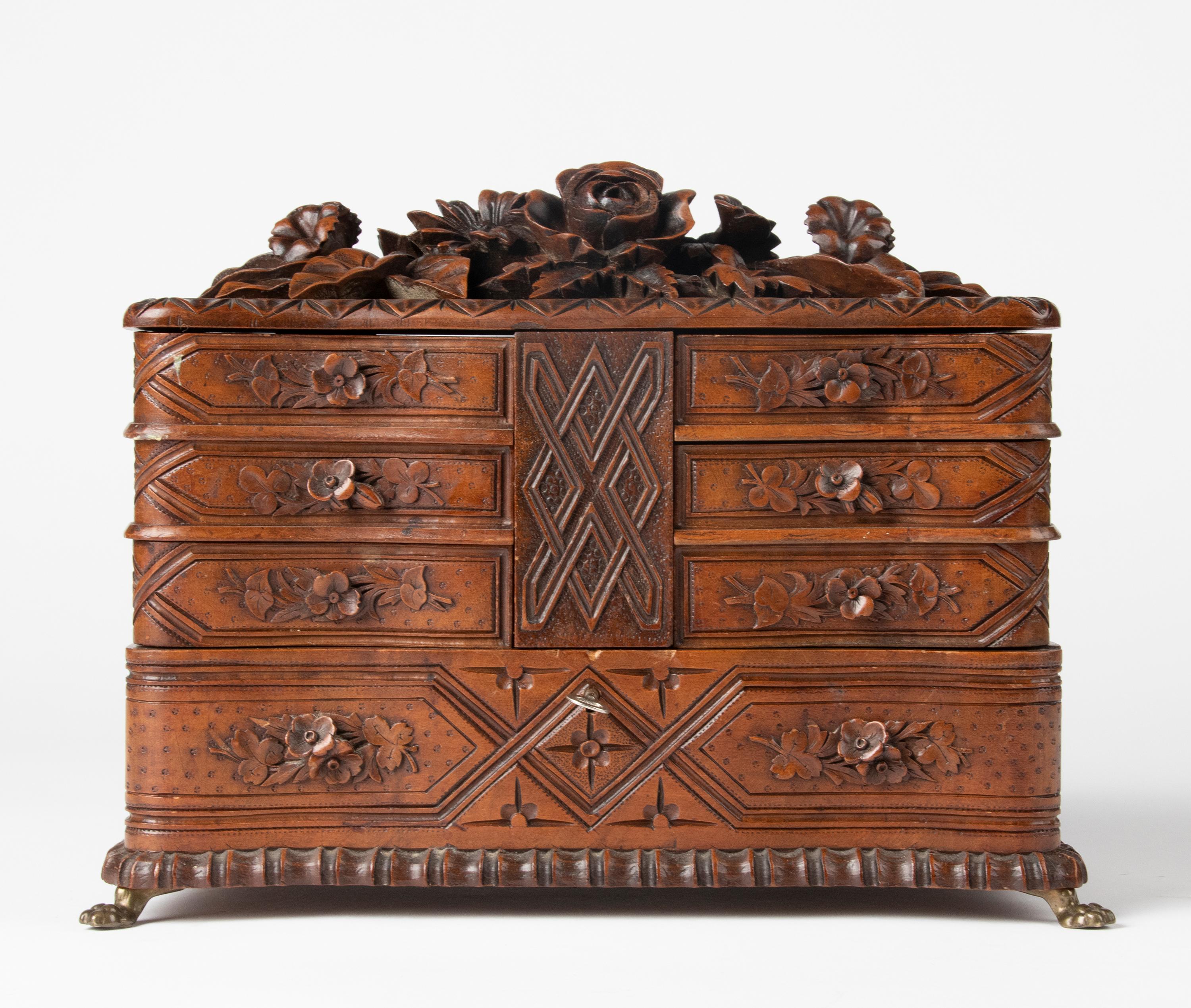 Beautiful wooden Black Forest chest, made of walnut. The chest has beautiful refined carvings with flowers and leaves. The box stands on copper claw feet. This object is in good condition and has a nice old patina.