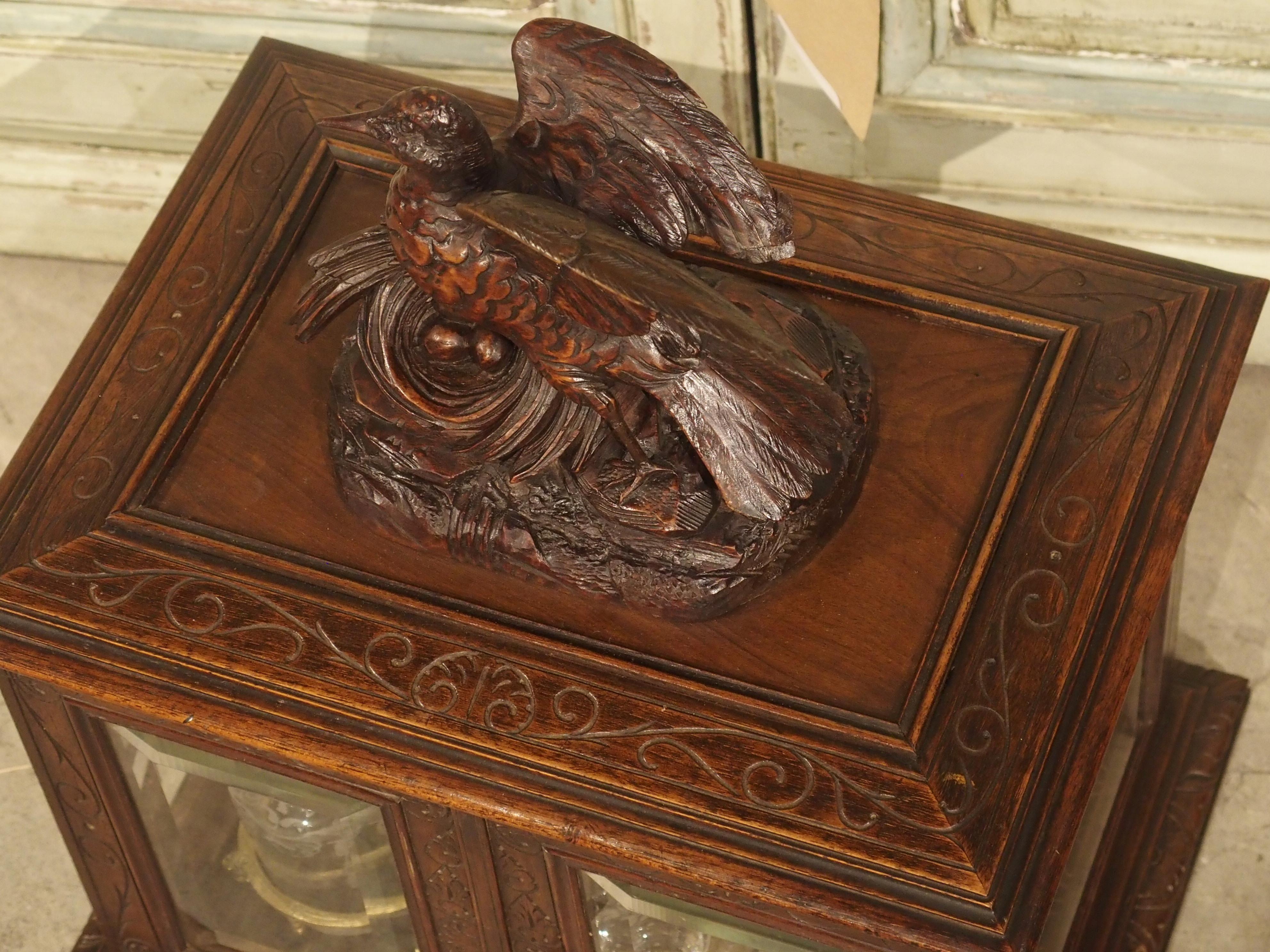 This large Black Forest walnut cave a liqueur is from 19th century France. The box has a working lock and key and the interior contents are visible through the beveled glass sides. In the 1800s, black forest carvings became a symbol of status and