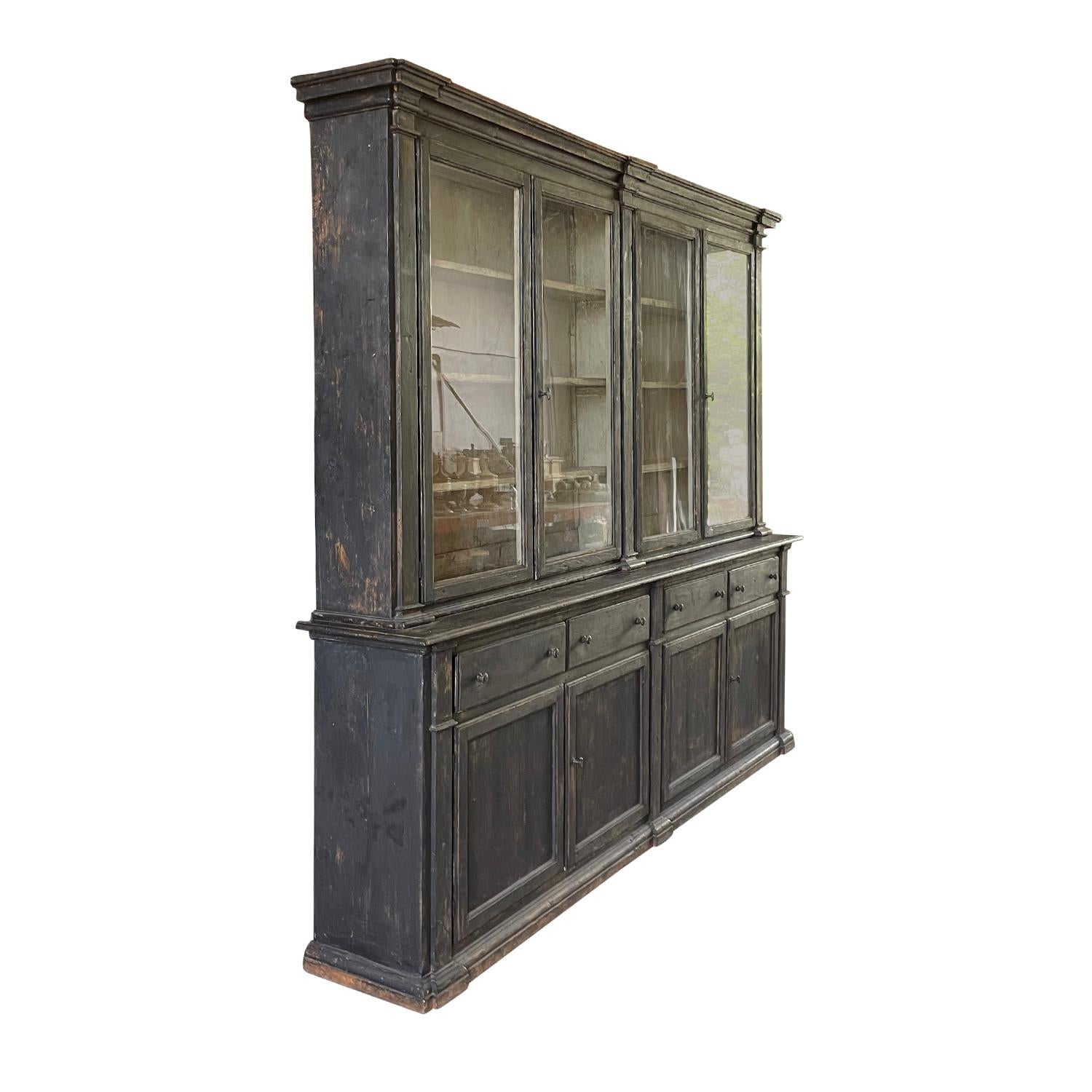 An antique French 19th Century large two-part library or meuble a deux corps anthracite black patinated, made of hand crafted Pinewood. The Provincial armoire has an ecru colored interior and simple lines. The lower part has double doors and four
