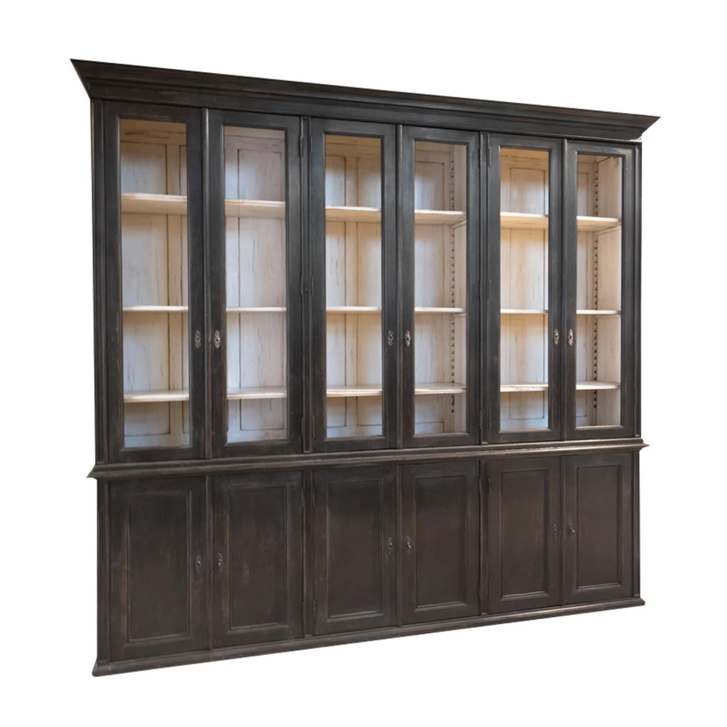A black, antique French two-part library with six clear glass doors made of hand crafted painted pinewood, in good condition. The upper part of the showcase is detailed with its original brass hardware and keys, the inside consists three adjustable