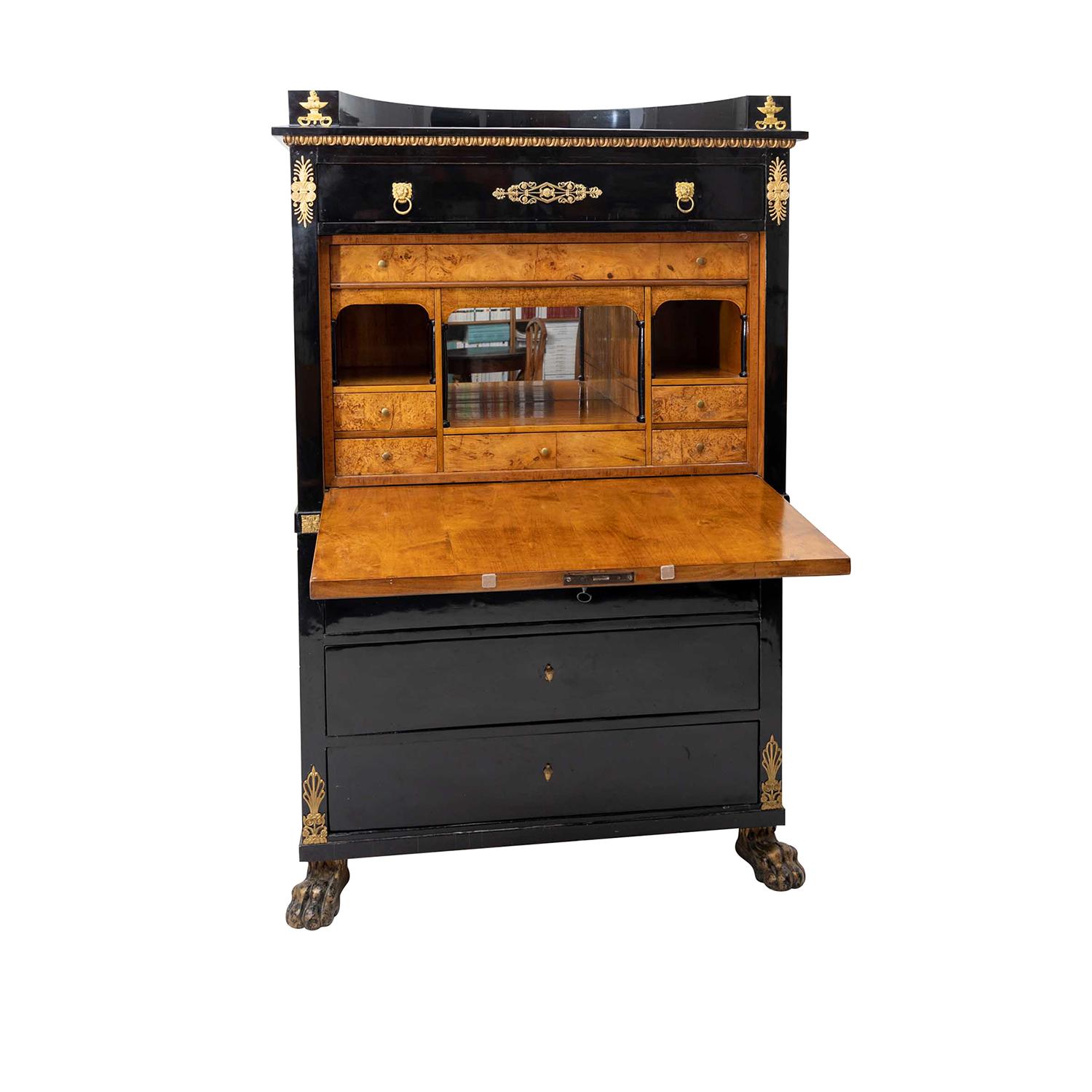 A black, antique French secretary with a writing flap made of hand crafted shellac polished, partly veneered Ebony, in good condition. The bottom part of the Parisian cabinet is composed with three large drawers, standing on four lion feet. The top