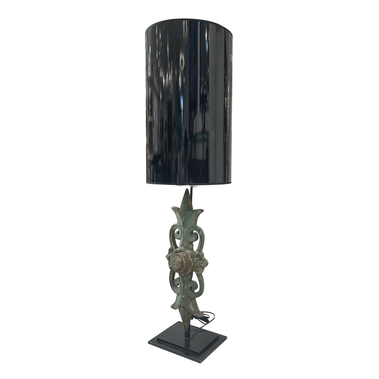 An antique French tall table lamp with a green iron ornament which is supported, halted by a black metal base, in good condition. The sculptural décor light is composed with a new black shade, featuring a two light socket. The wires have been