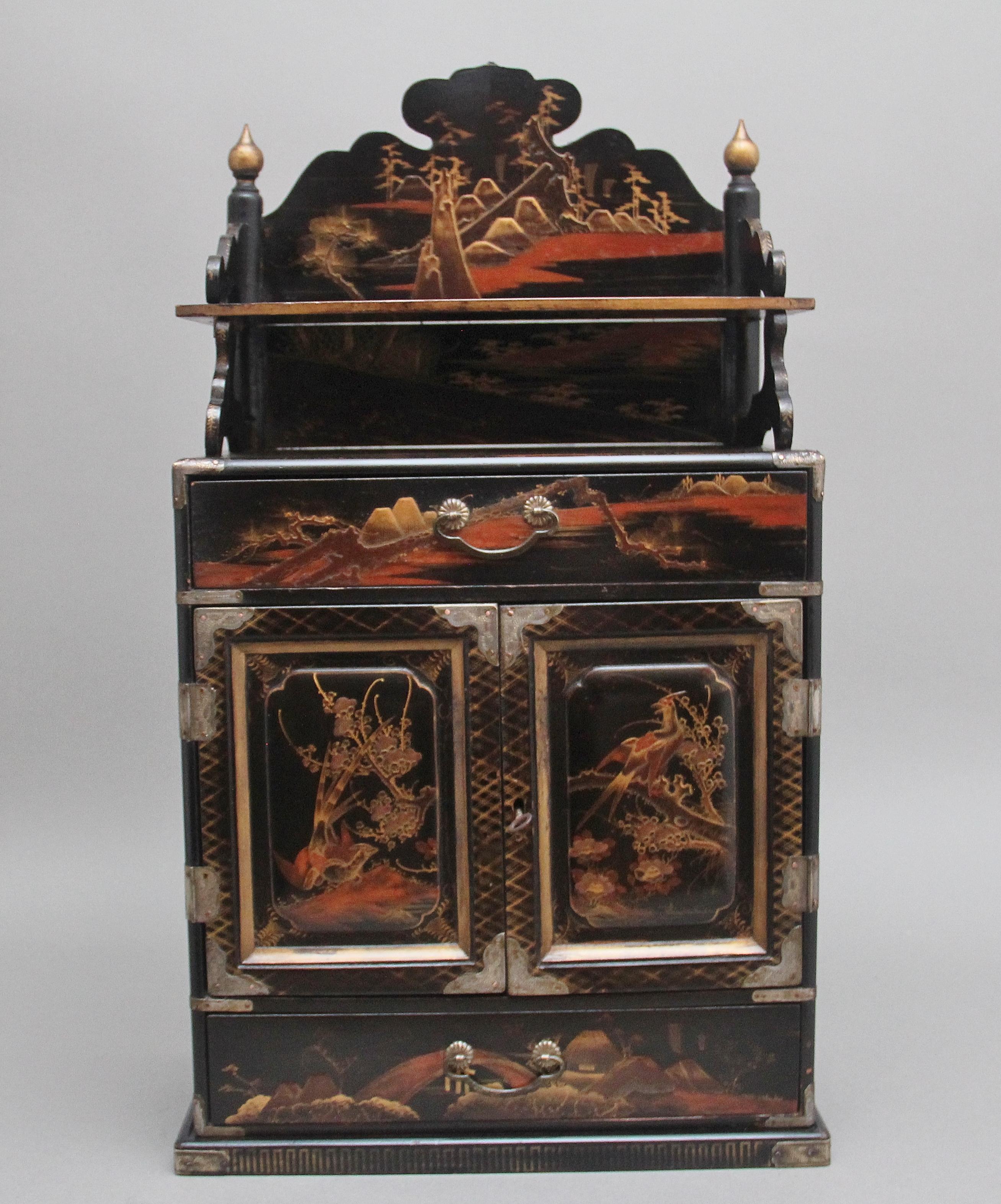 19th Century freestanding Japanese black lacquered and painted table top cabinet from the Meiji period (1868-1912) The cabinet throughout depicting Japanese countryside scenes, various foliage and birds, the top structure having a decorative shaped