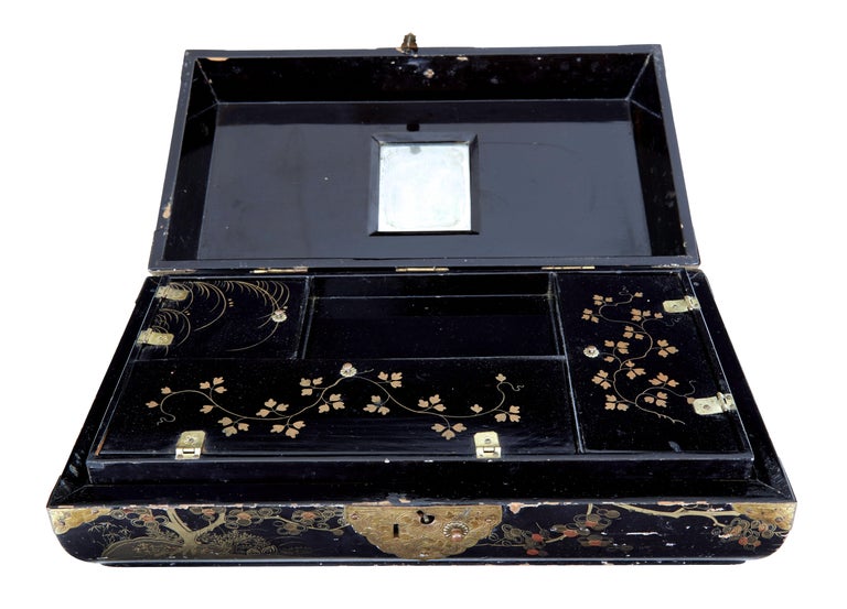 19th century Chinese black lacquered jewellery box circa 1860.

Good quality shaped Chinese jewellery box with overstuffed top cushion. Hand painted in gold leaf on all surfaces, with the main feature being on the front. Original decorative metal