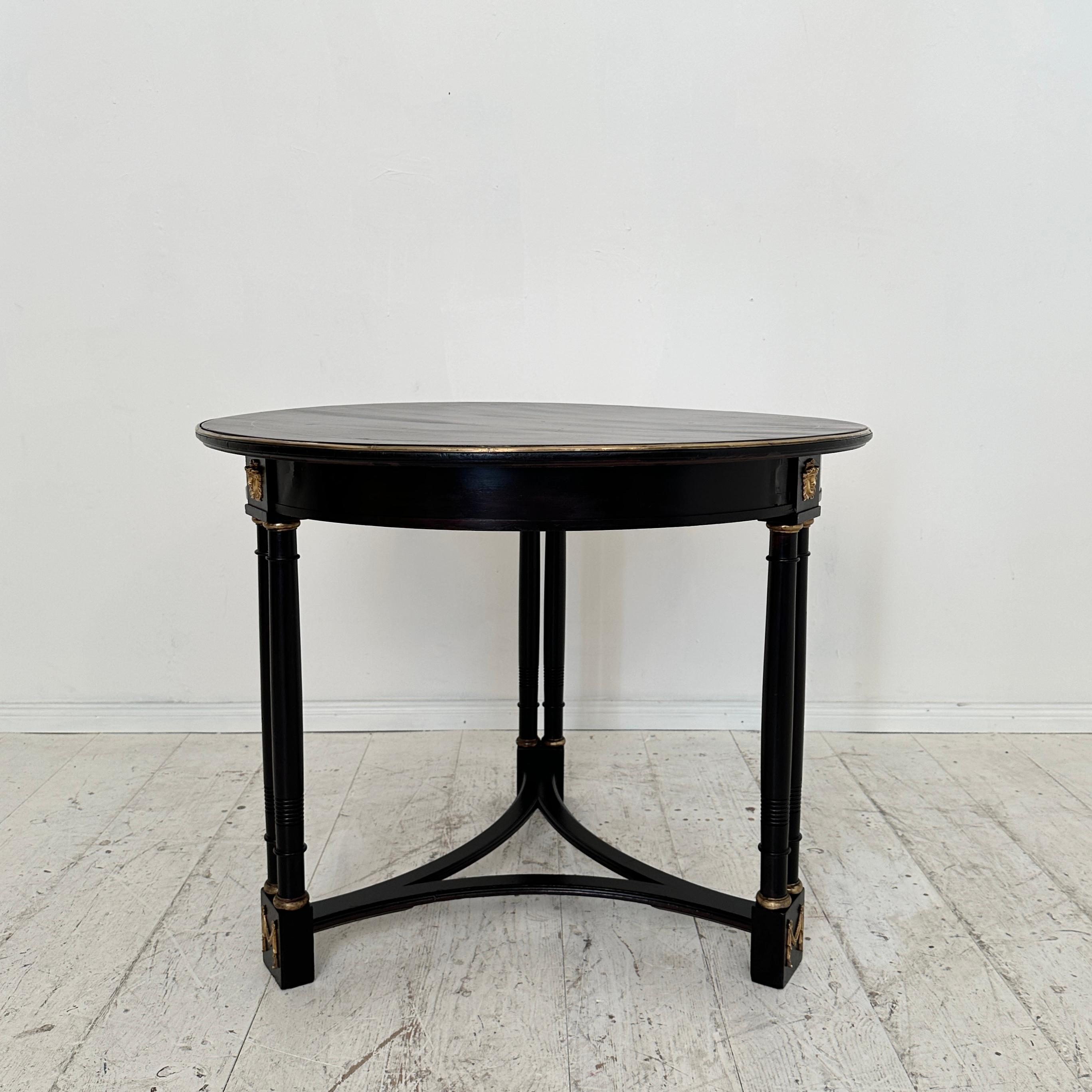 Crafted circa 1870, the 19th Century Black Round Gueridon Table epitomizes the lavish elegance of the Empire style. With its sleek black hue and graceful curves, it stands as a testament to the opulence of the era. Adorned with intricate detailing