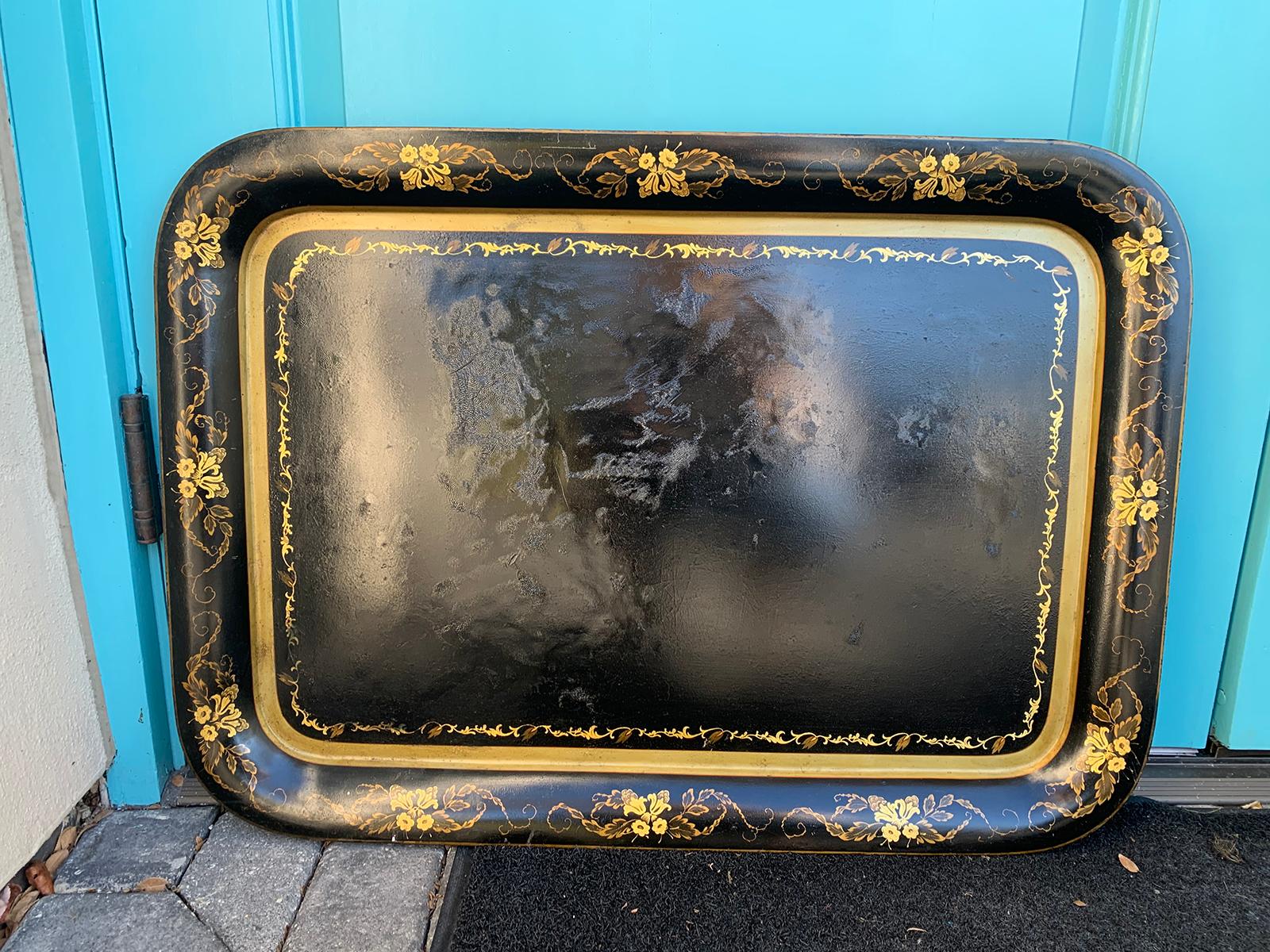 19th century black tole tray with gilt flower border.