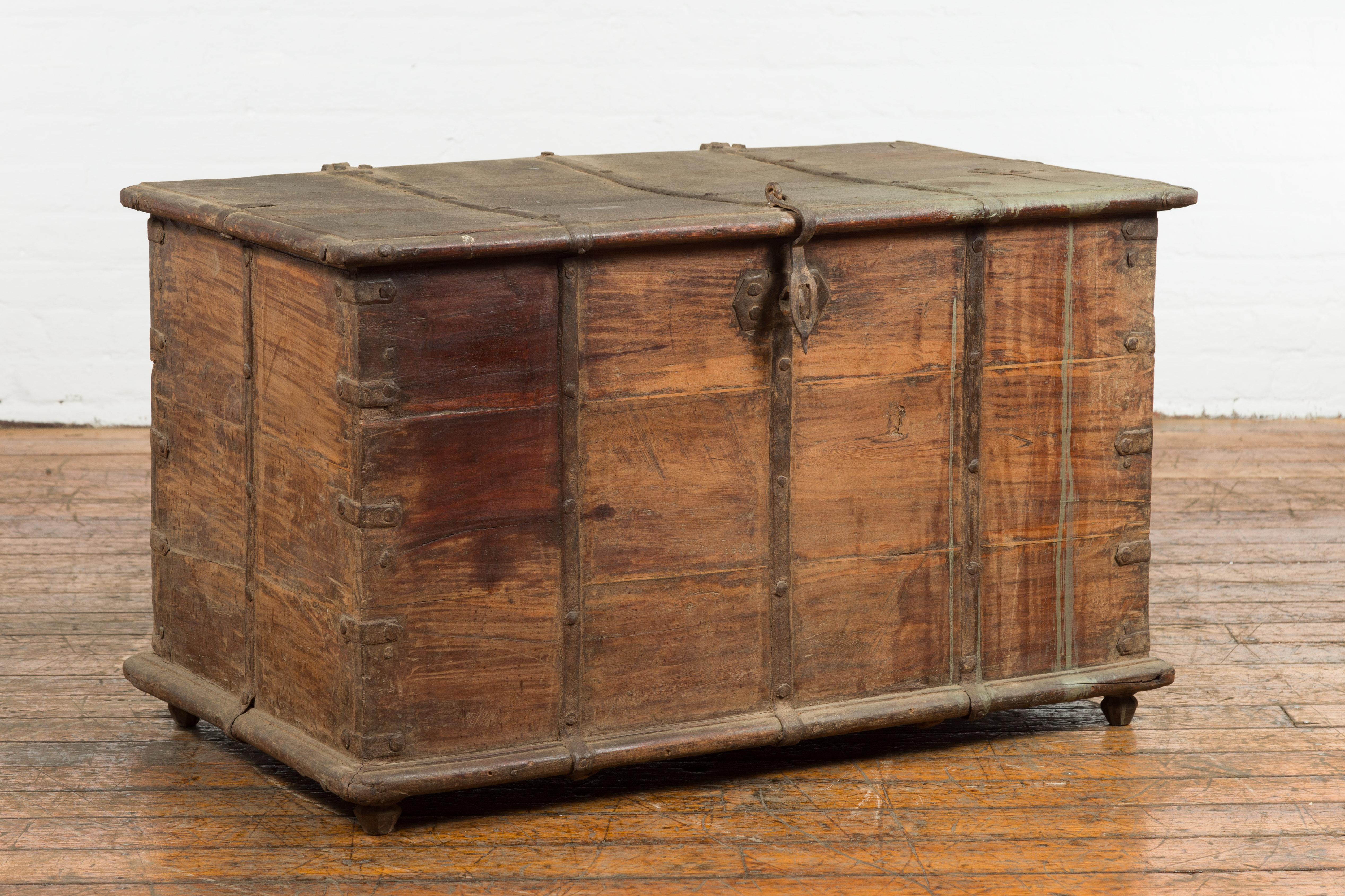 An Indonesian wooden blanket chest from the 19th century with brass hardware and rustic character. Introducing this 19th-century Indonesian wooden blanket chest, a charismatic fusion of functional design and rustic aesthetics. Crafted meticulously