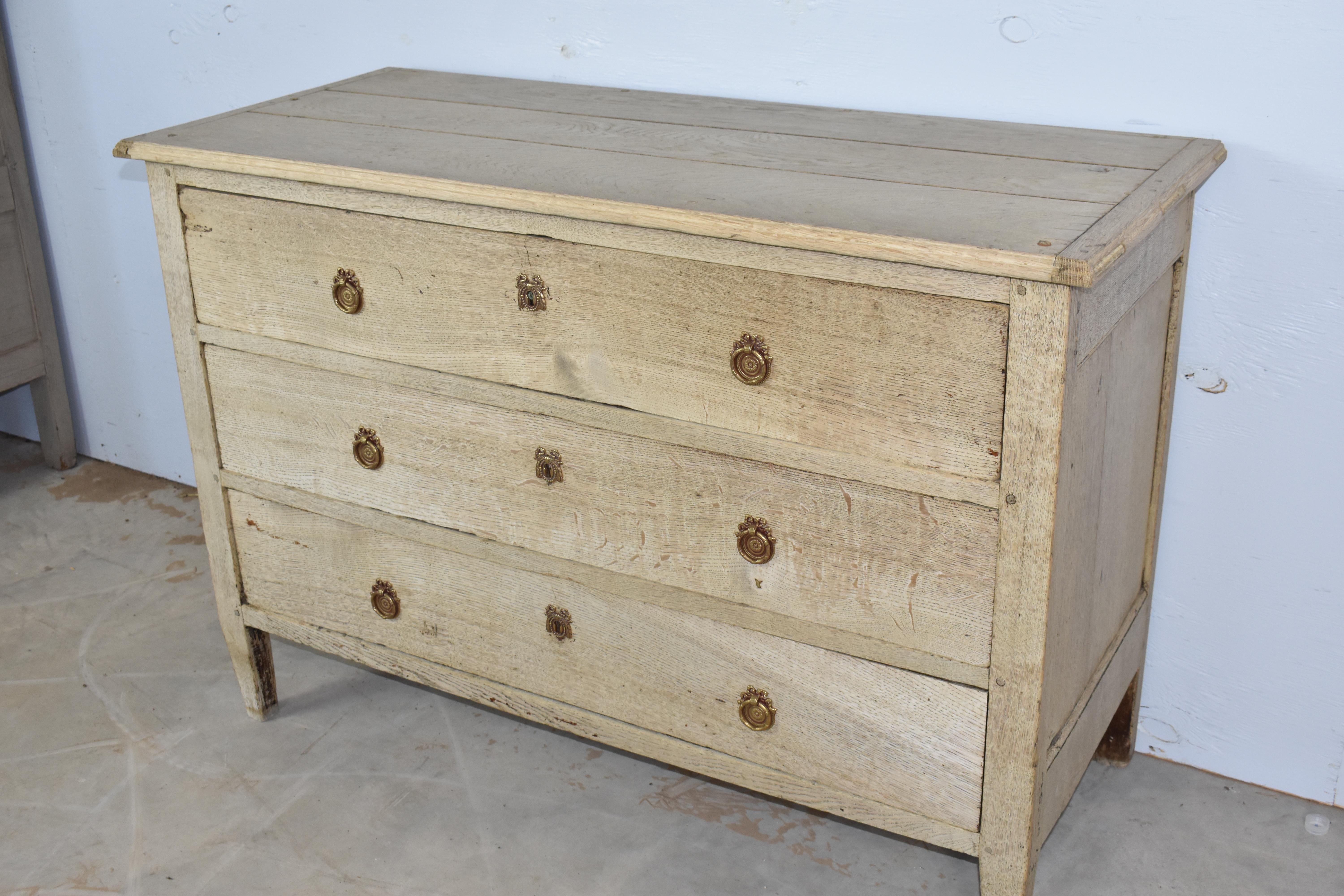 Louis XVI style commode made in France using oak and pegged construction in the early 1800s. The chest has very straight lines and sits on short, tapered legs. The three inset drawers are, roughly, all the same size and will provide plenty of