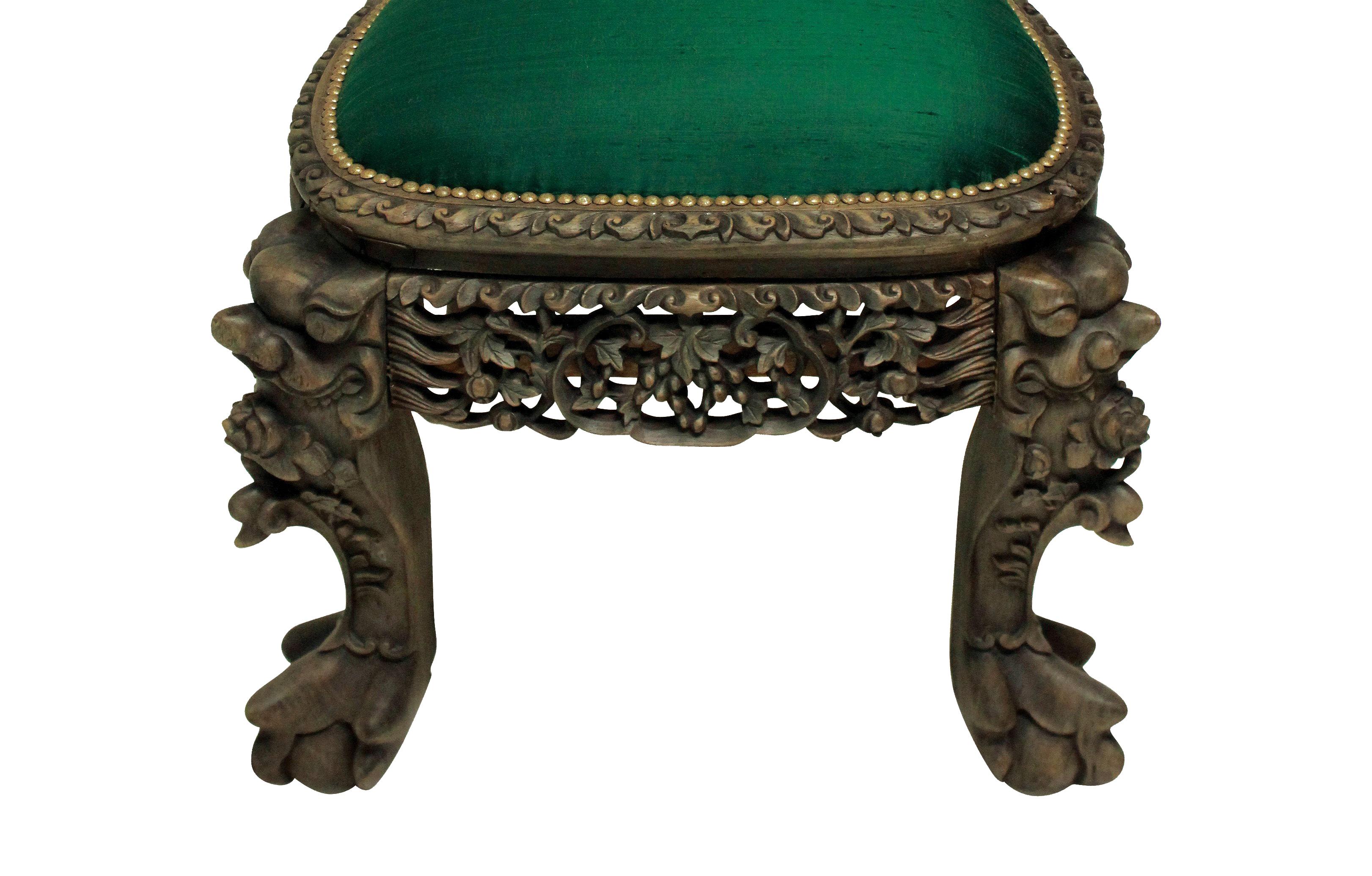 A beautifully carved 19th century Chinese bleached hardwood chair. Depicting beasts and dragons among foliage, upholstered in emerald green silk.

  