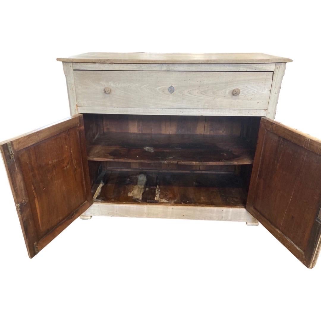 Louis Philippe buffet hand-made in central Italy in the early 1800s using walnut. This is a very straight-lined credenza that because of it washed out color and proportions looks both rustic and elegant at the same time. The buffet has a one over