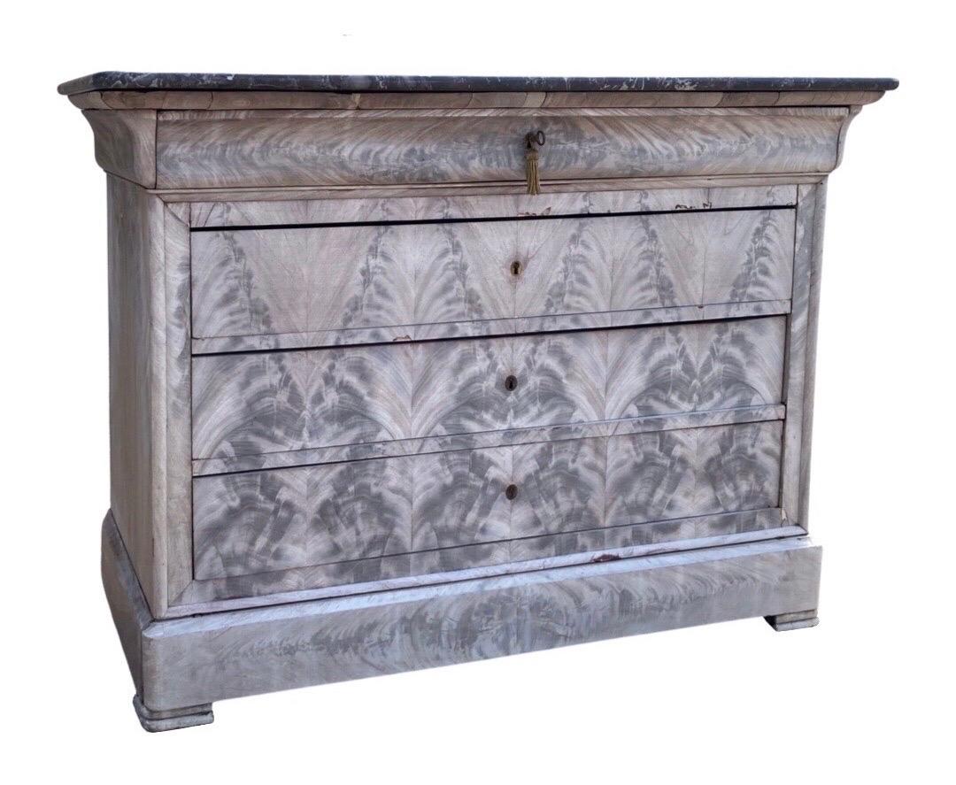 Louis Philippe chest of drawers with black marble top hand-made in France in the mid 1800s using mahogany. The commode features the typical details of the Louis Philippe style with very simple and straight lines, no carving but molding to produce
