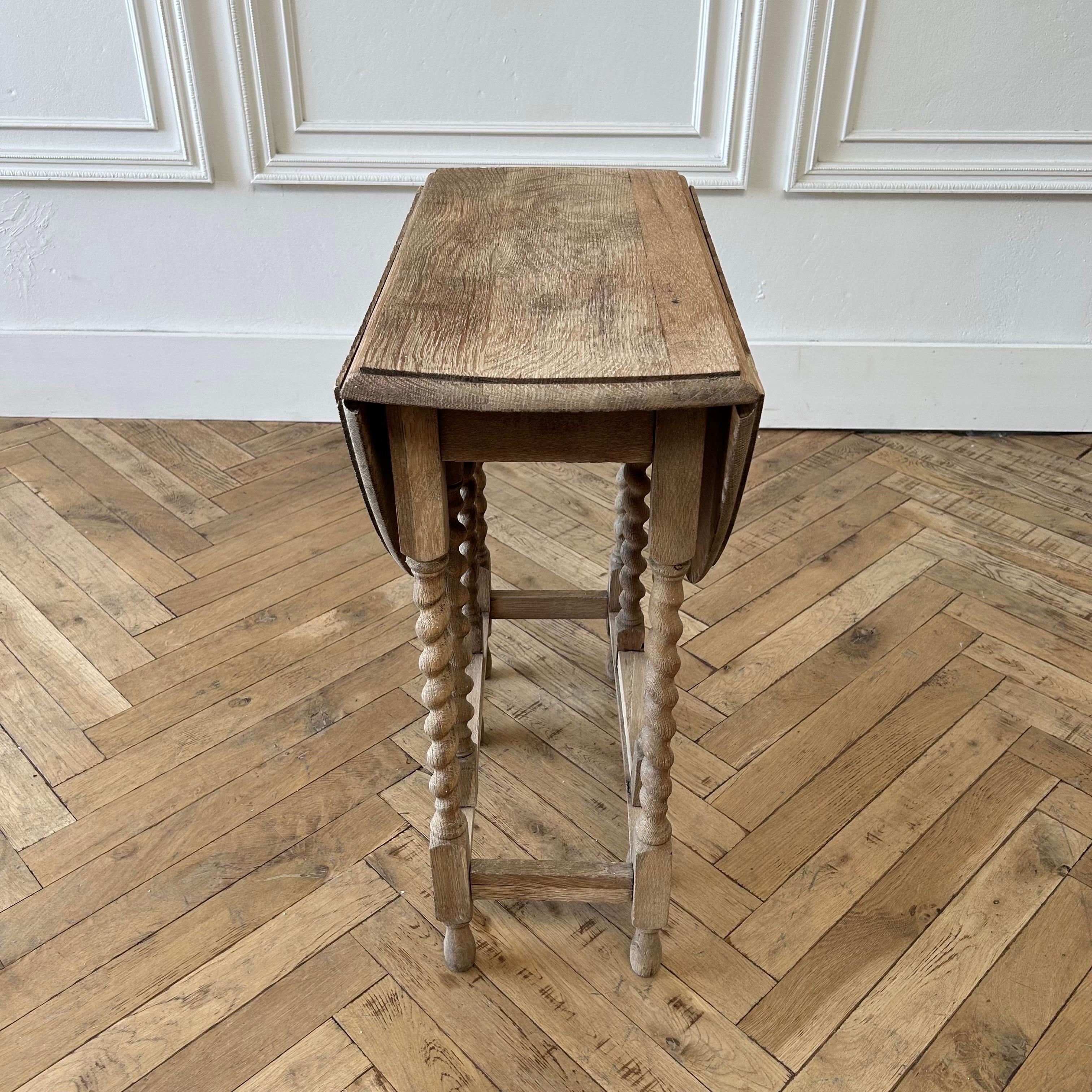 A French carved double gate-leg table from the early 19th century. 
Oak table 35”W x 24”D x 28-1/2”H.
Folded: 12-1/2”W
This antique table from France has an oval-shaped top with two drop leaf sides, that when down, make this medium sized table, a