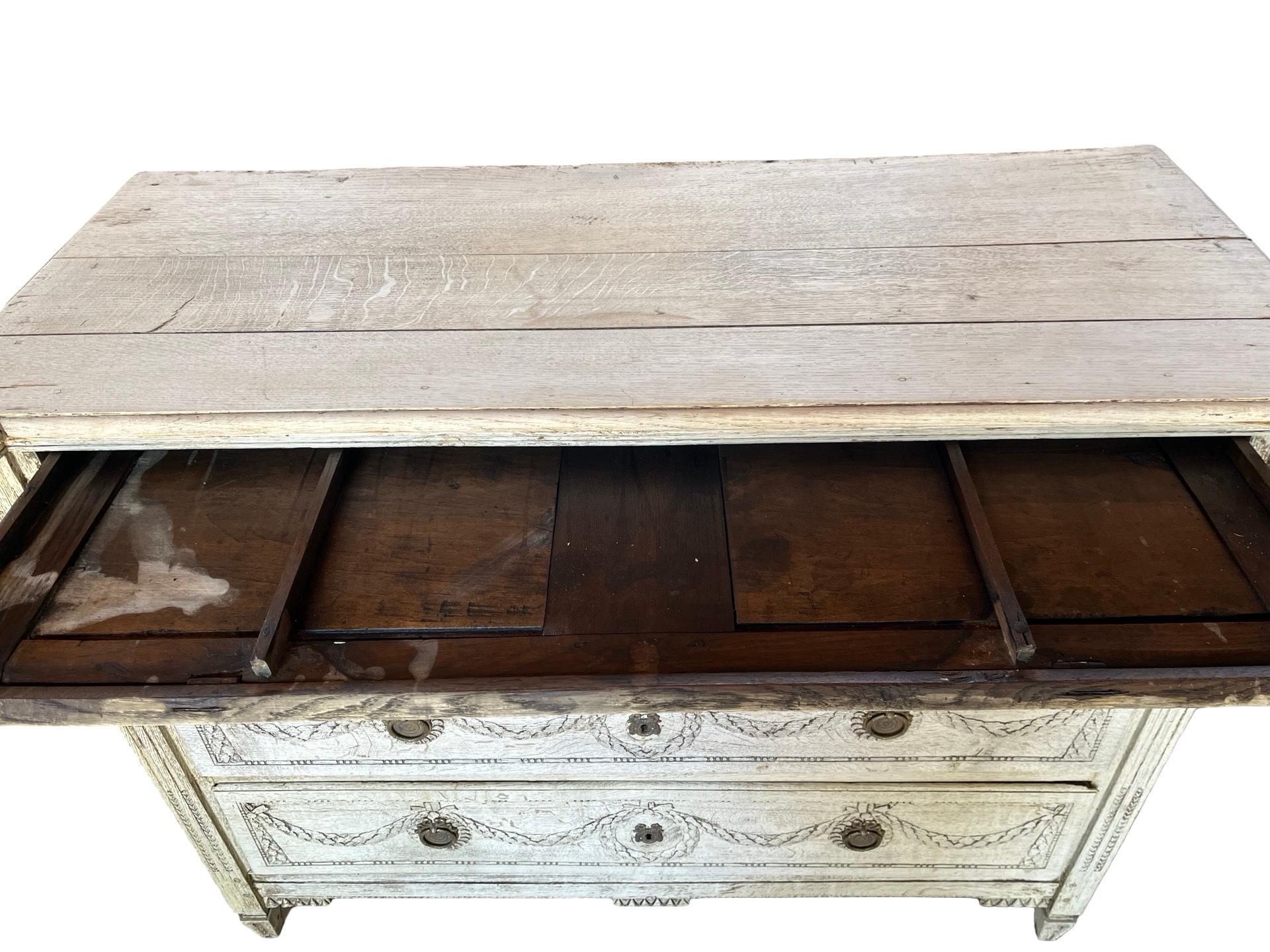 Chest of drawers hand-made in Belgium in the early 1900s using oak and pegged construction. The chest features three overlay drawers, all showing large, hand-made dovetail joints and  beautifully decorated with floral carvings on the fronts. The
