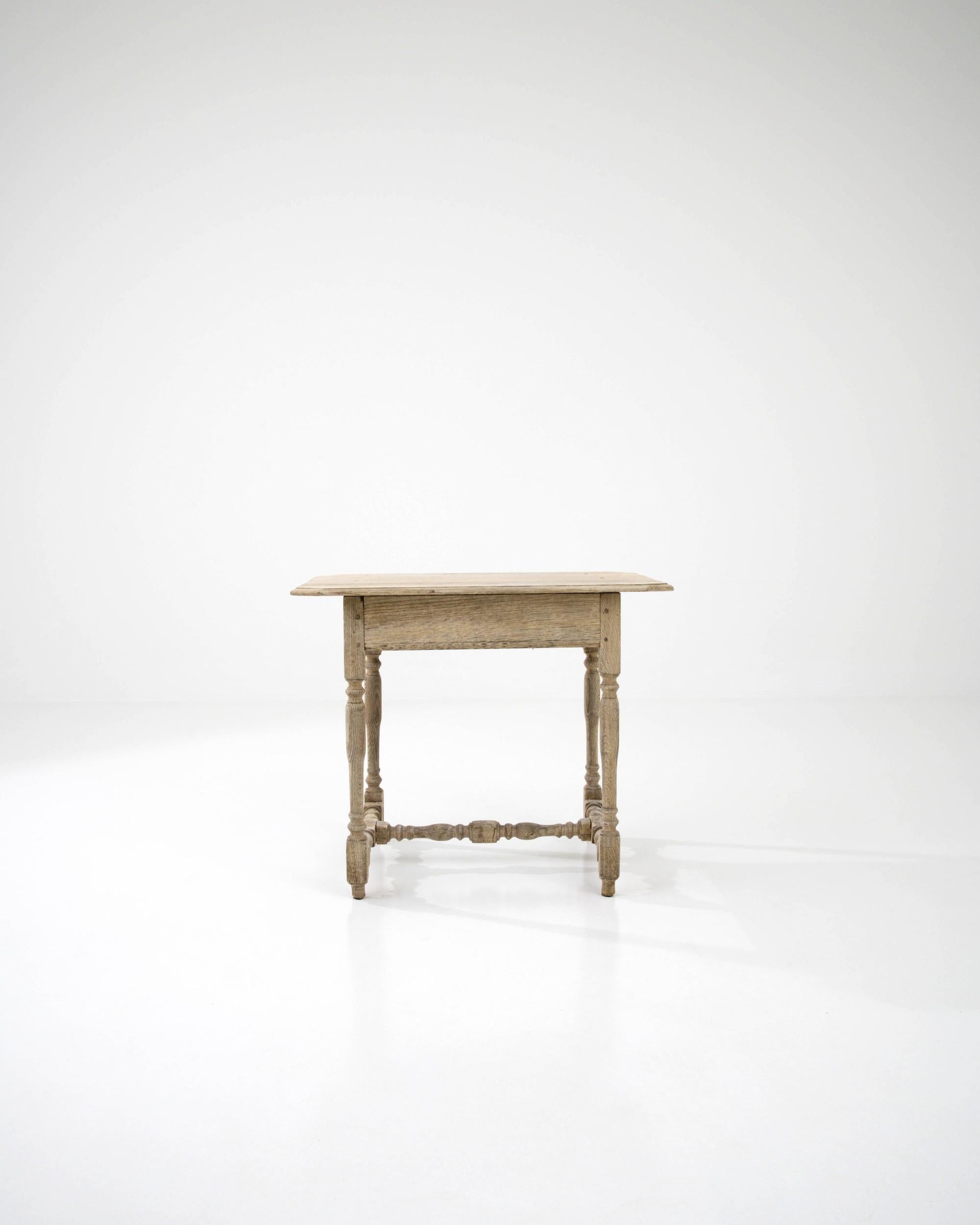 This elegant French Provincial side table in natural oak is a vintage find to treasure. Built in France in the 19th century, the turned shape of the legs and stretcher create an eye-catching profile. The simplicity of the design recalls the pastoral