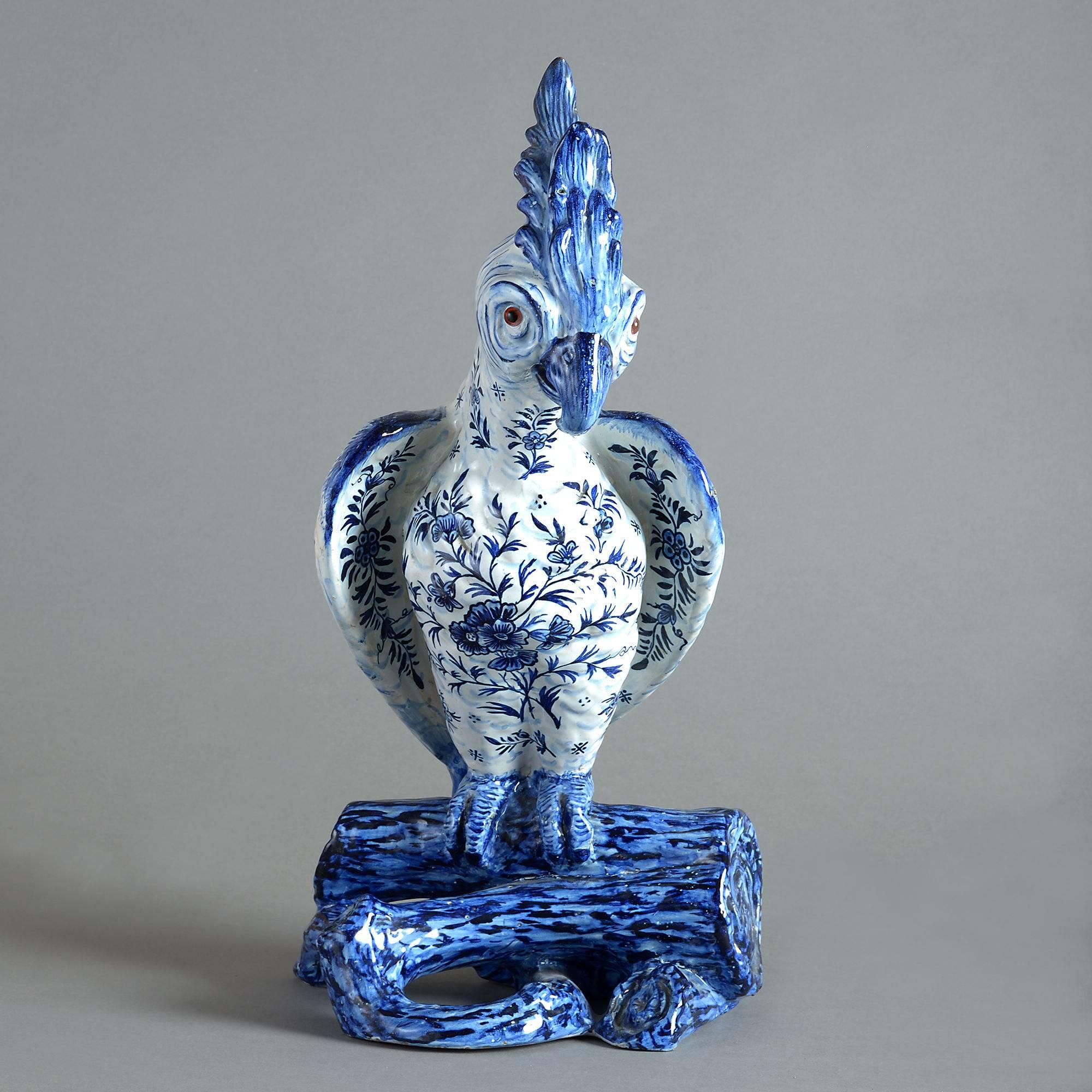 A highly decorative blue and white glazed pottery parrot of good scale, naturalistically modelled, its body decorated throughout with floral and foliate motifs.
 
