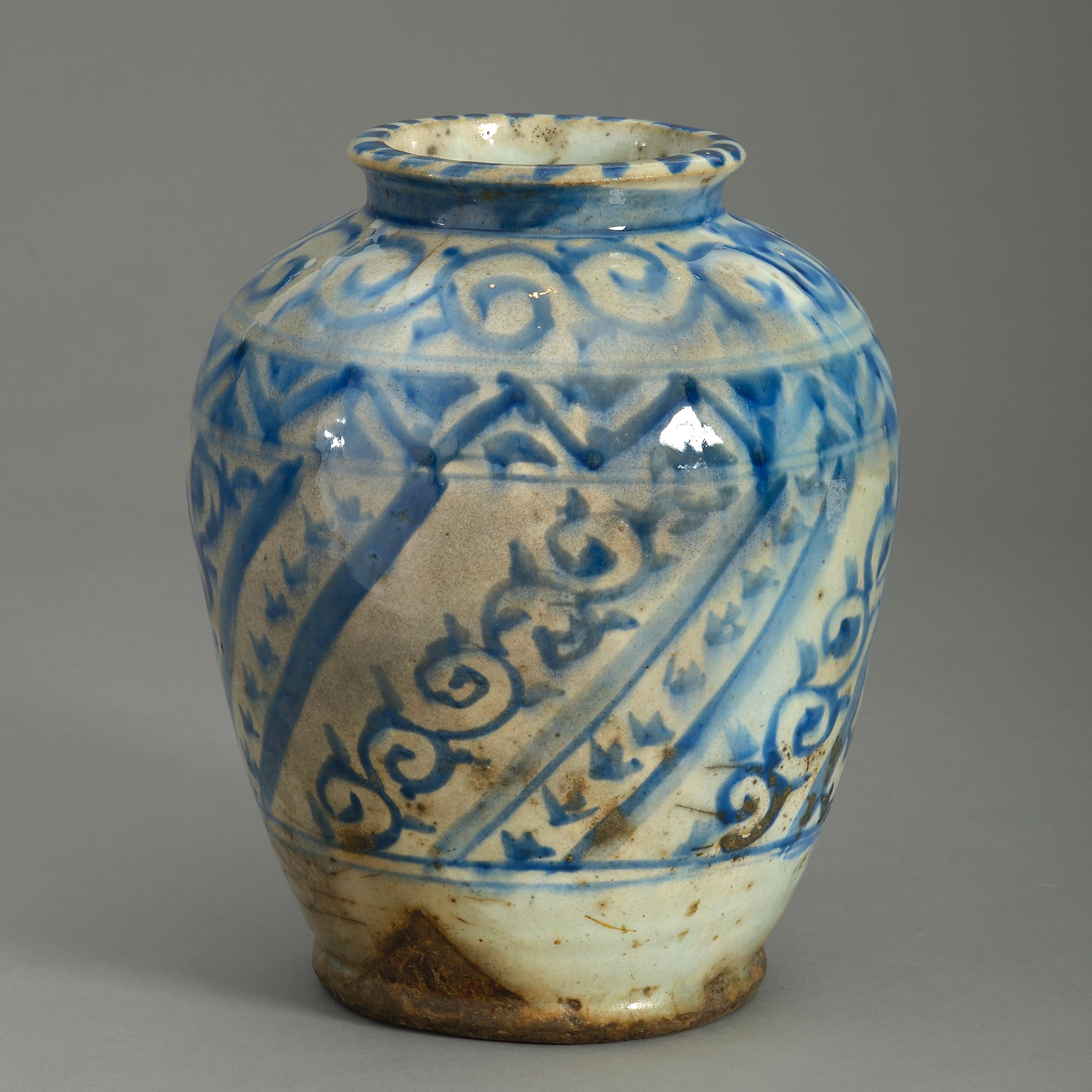 A charming late 19th century Persian pottery vase, decorated throughout with scrollwork and banding in blue glazes upon a white ground.
