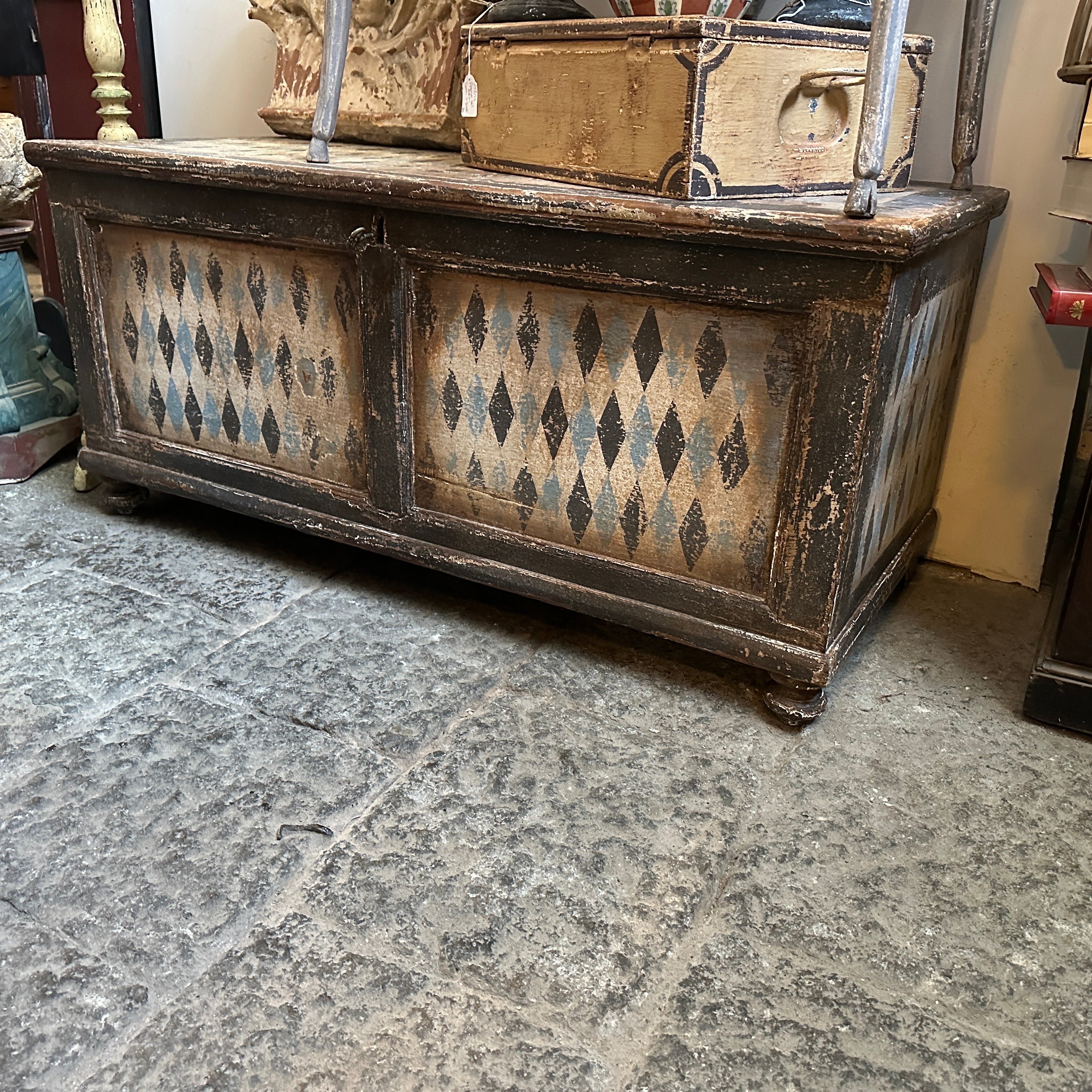 A Tuscanian blanket chest hand-crafted in Italy in the late 19th century, it's in original conditions and it has normal signs of use and age. The blue, white and black decor depicts rhombus motifs and it's suitable for modern or classic ambient. The