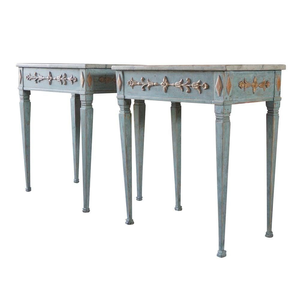 A blue-grey, antique Swedish Gustavian pair of console tables made of hand carved Pinewood, scraped down to its original light blue color. The richly hand crafted console tables are in good condition, designed in the neoclassical Greek style,
