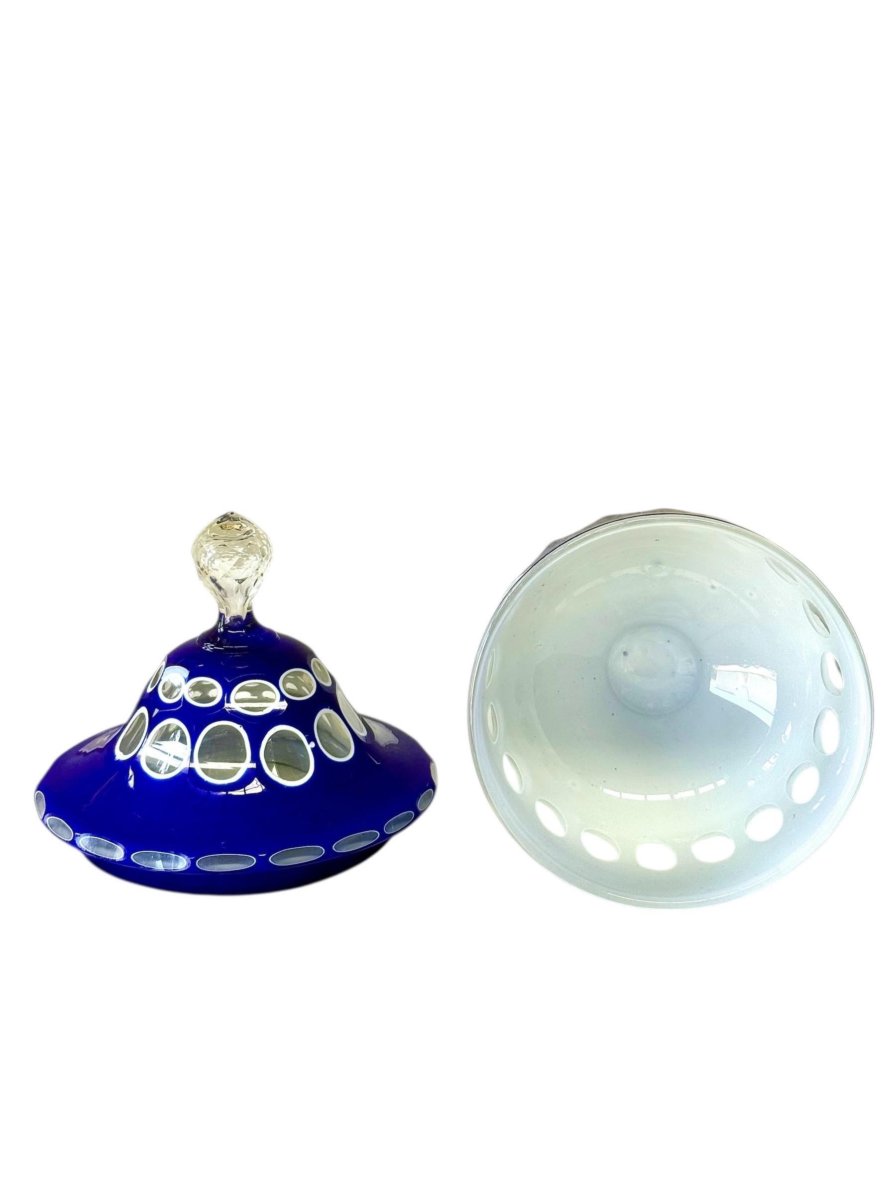 Magnifique drageoir couvert de verre bleu du milieu du XIXe siècle, qui témoigne du raffinement et de la précision de la verrerie de Bohême. L'enveloppe bleu cobalt profond a été délicatement découpée pour révéler une couche opaline laiteuse, selon