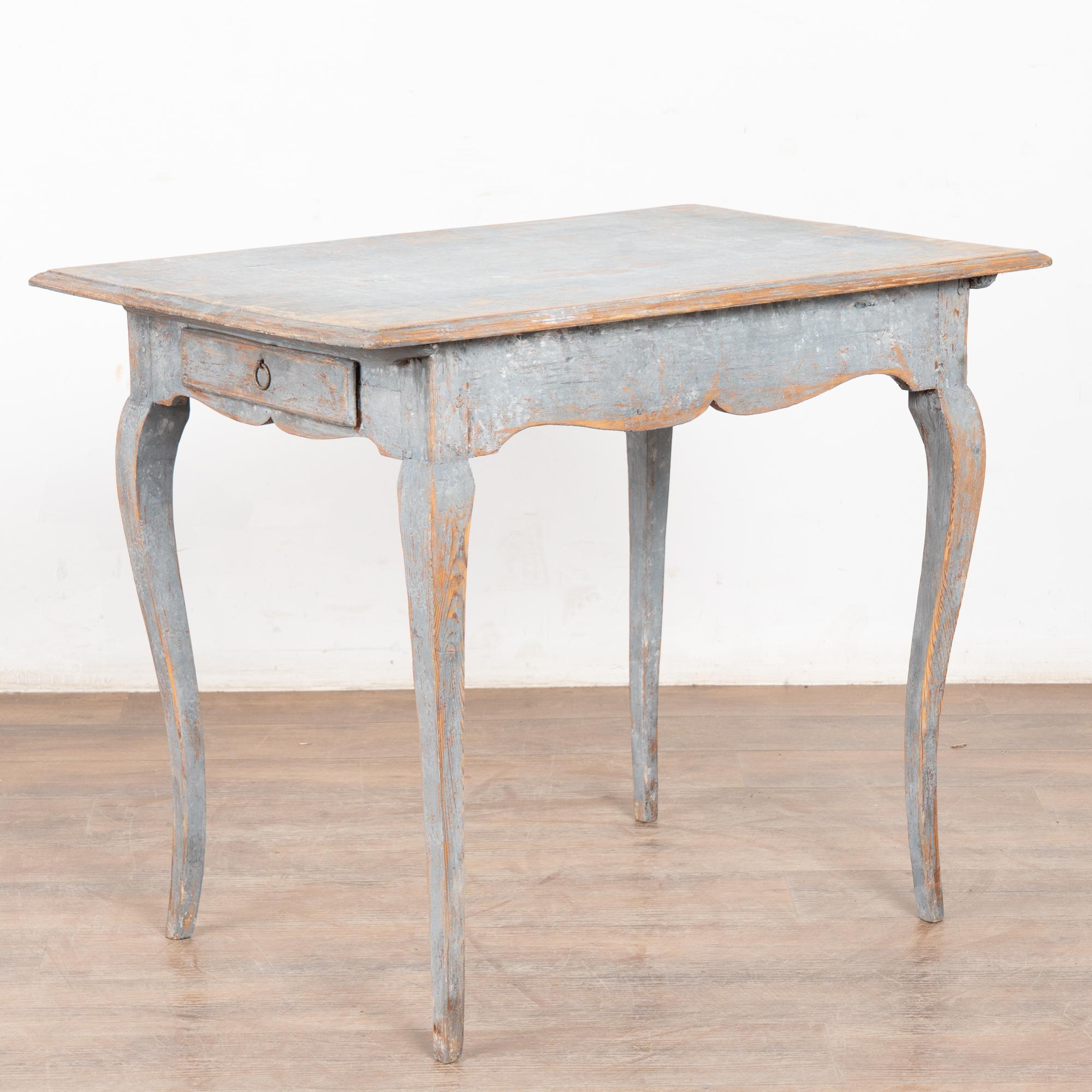 The curved cabriole legs add a charming touch to this pine side table with two drawers (one on each end) which is originally from the Swedish countryside.
The original blue gray painted finish has been much distressed through generations of use,