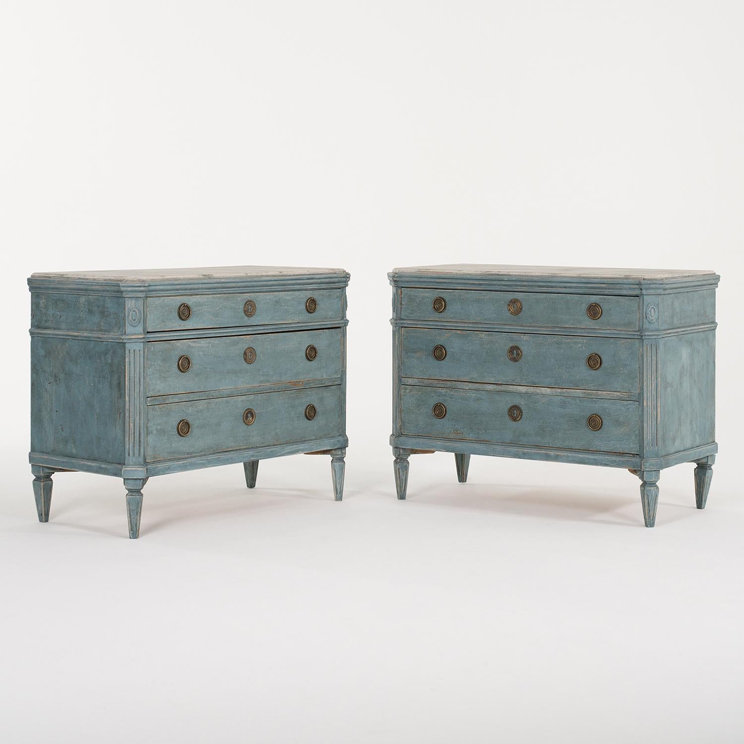 A 19th Century, light-blue antique Swedish Gustavian pair of chests made of hand crafted painted Pinewood with two large drawers and one small one, in good condition. The Scandinavian cabinets are composed with a hand painted white faux marble top,