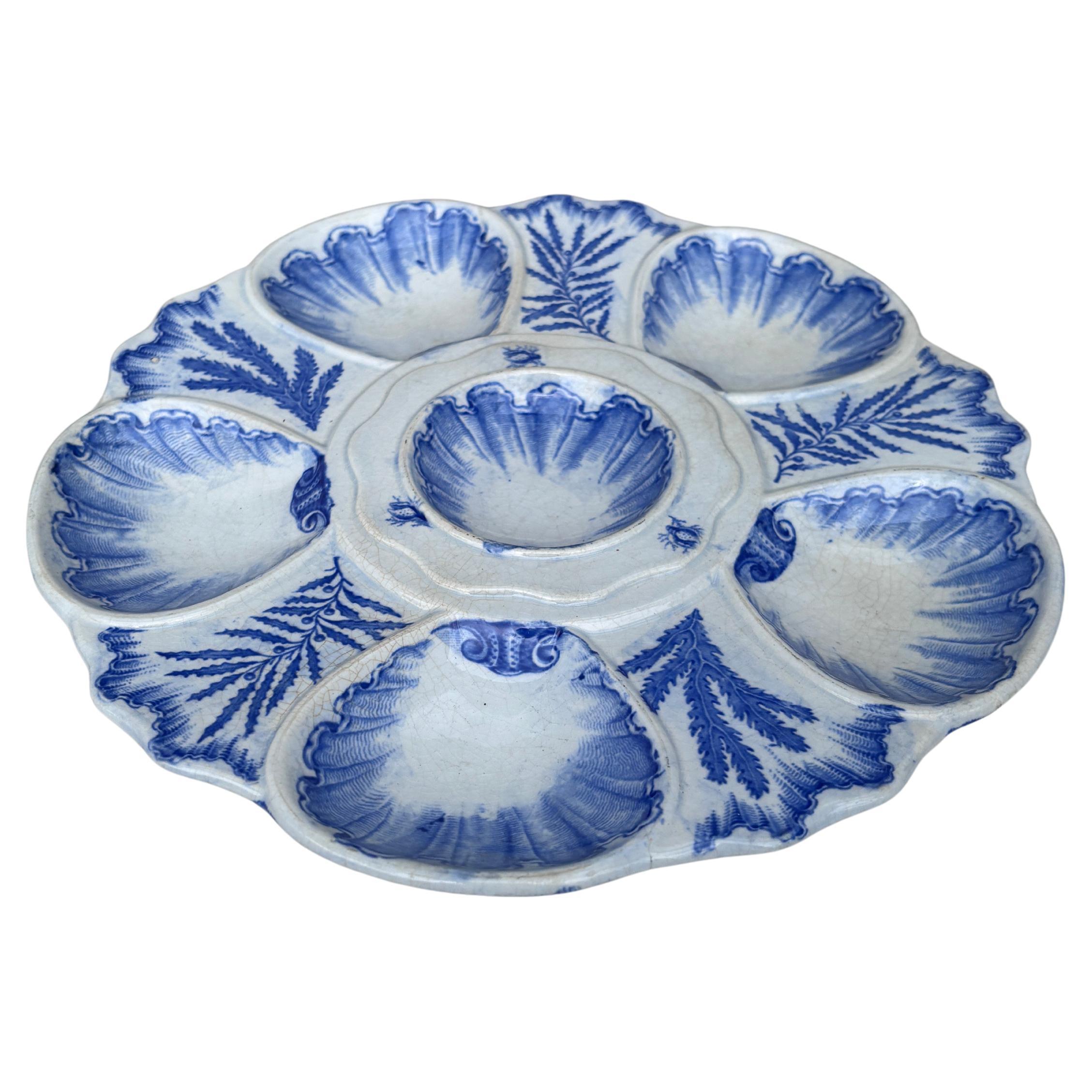 Elégante assiette à huîtres bleue et blanche signée Bordeaux Vieillard, vers 1890.
Six puits entourés d'algues bleues de différentes sortes.
Réf / 2732.