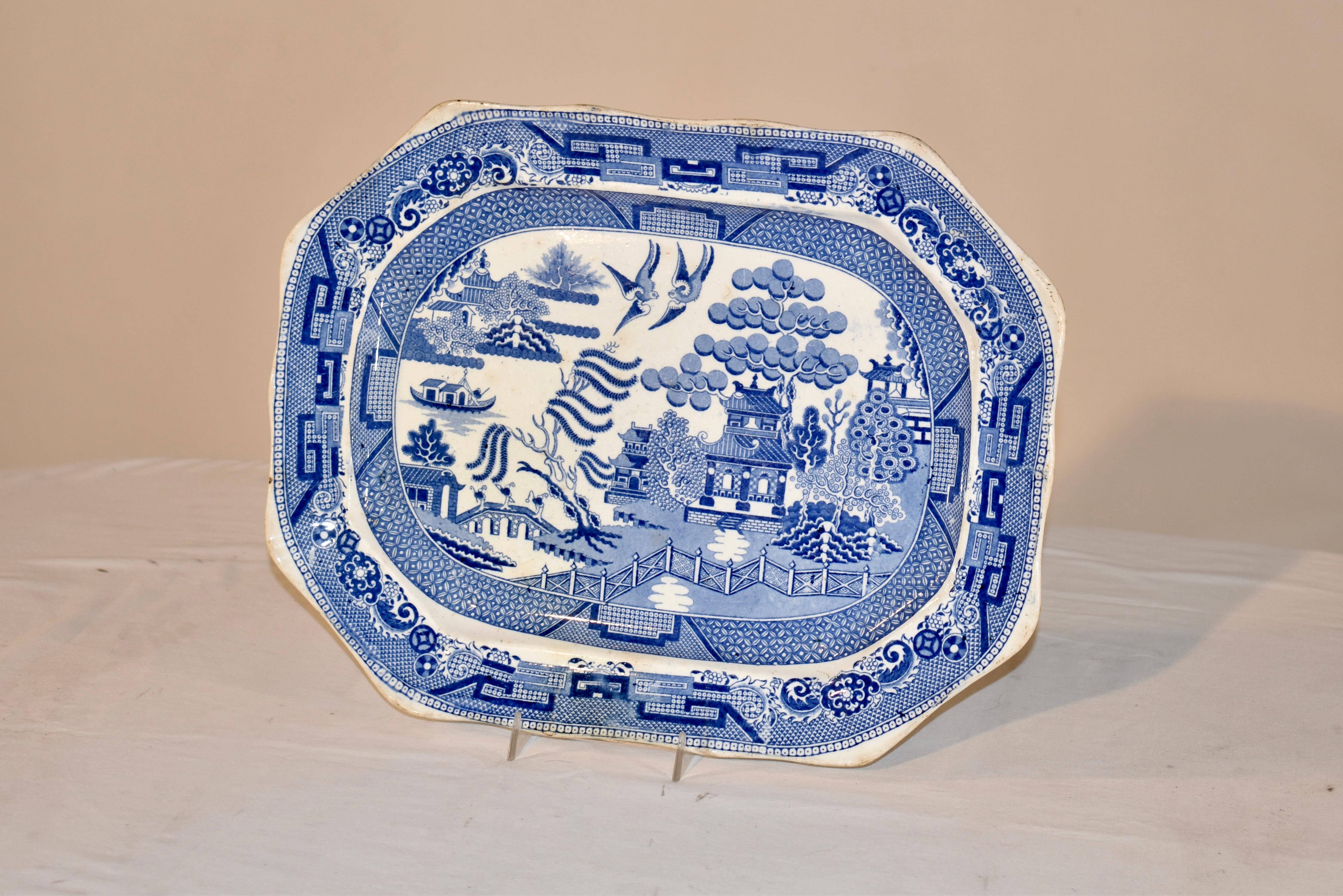 19th century porcelain platter attributed to Davenport.  This platter is decorated in the highly collectible Blue Willow pattern.  The platter is unusual in that it has a lovely shaped border, for more design interest.  On the back of the platter,