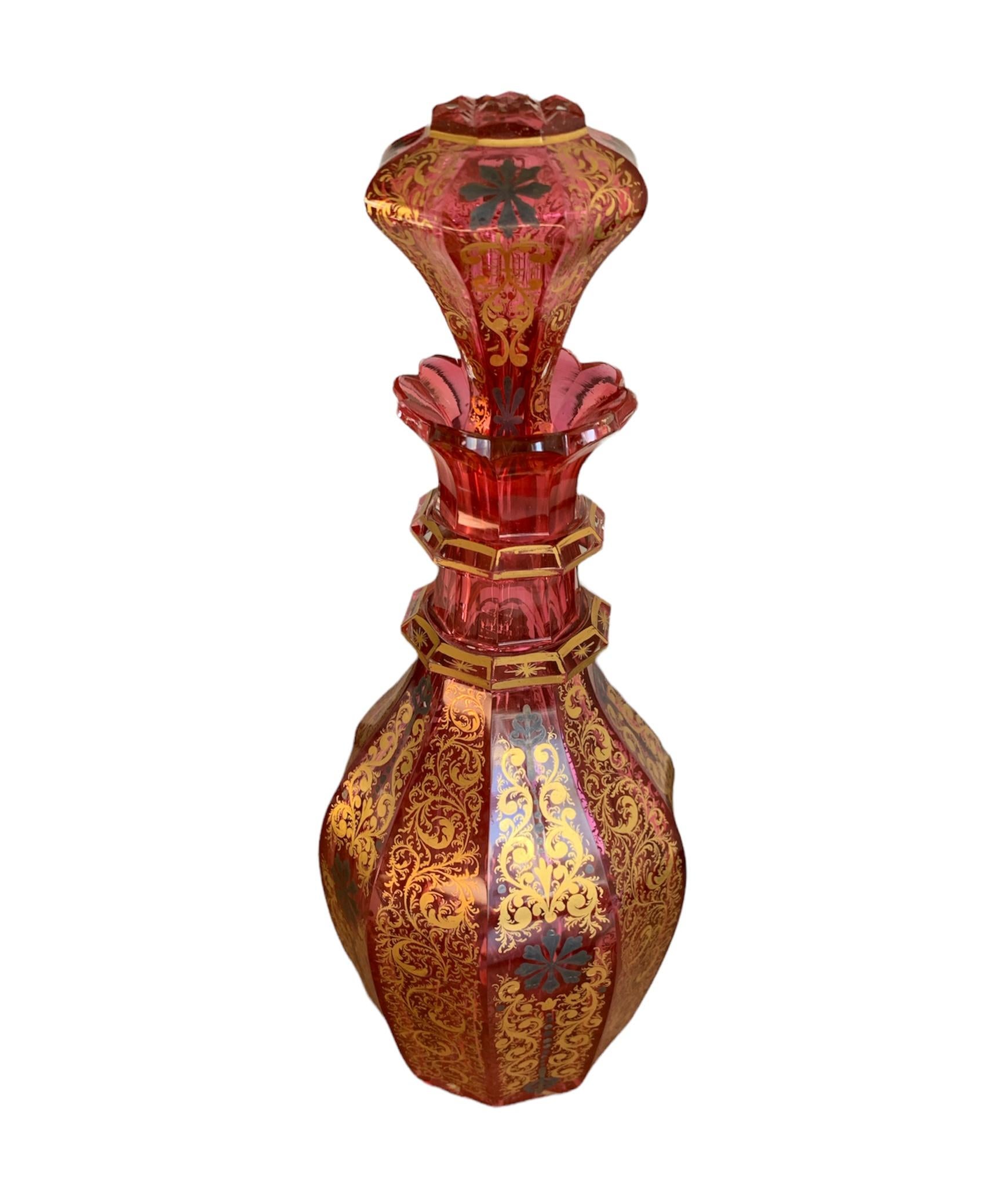 A very unusual and exquisite 19th century Bohemian crystal carafe with its original stopper. Red cranberry glass with rich gold decoration. This rare carafe shows the highest quality of the 19th century Bohemian glass artists. The body is decorated