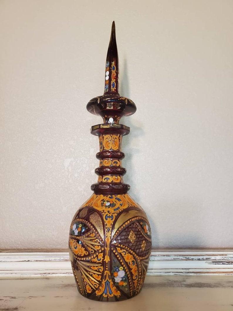 A brilliant Bohemian ruby cased and polychrome enameled cut glass decanter with stopper from the 19th century. Exquisitely handcrafted and detailed for the Islamic market, having Middle Eastern design influence, with an elongated steeple-form