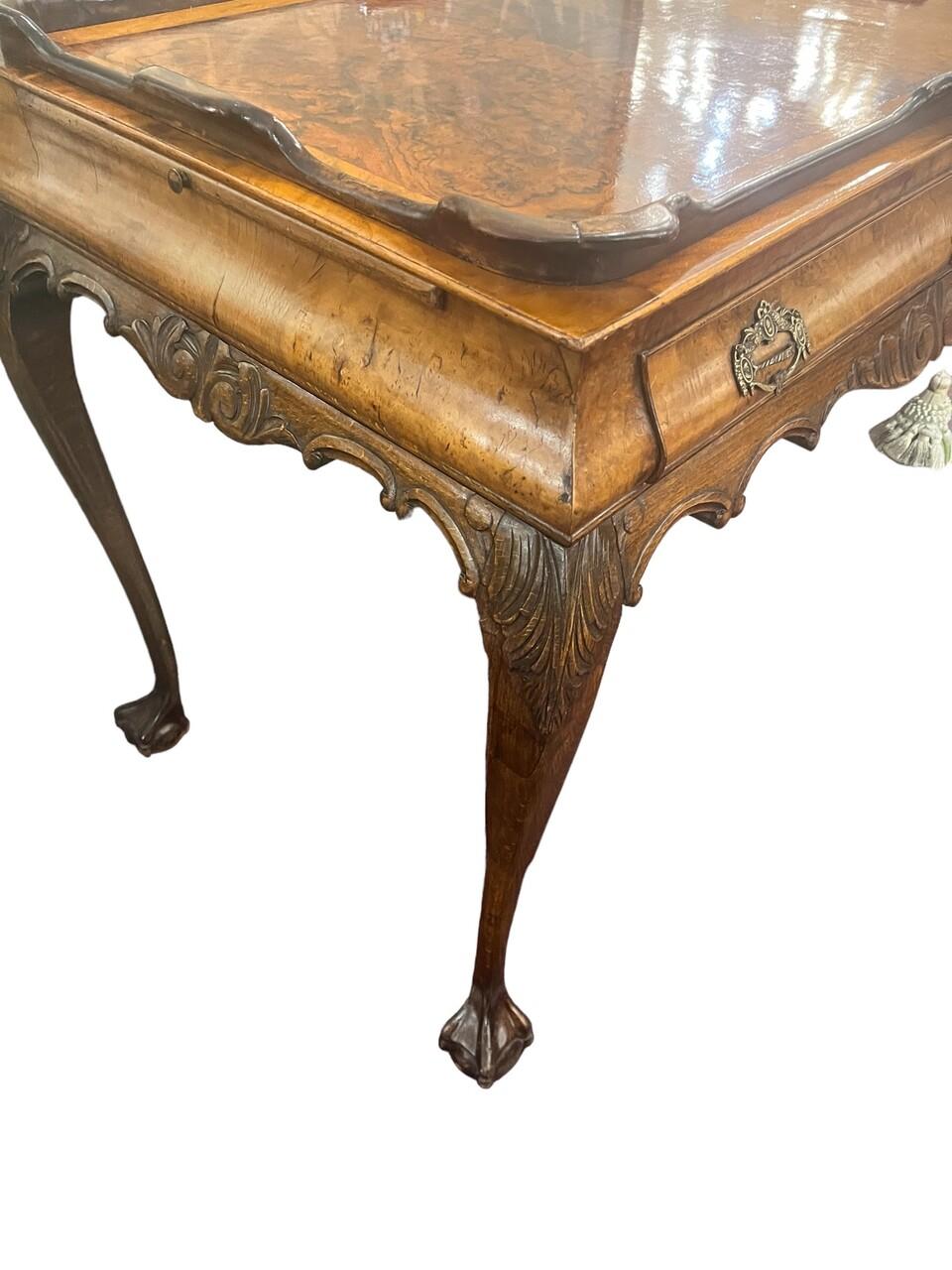 Magnifique vestige de l'artisanat du XIXe siècle, cette table à thé rayonne d'élégance et de praticité. Fabriqué en ronce de noyer exquise, sa beauté est à la hauteur de son design fonctionnel. Les côtés escamotables garantissent la polyvalence pour