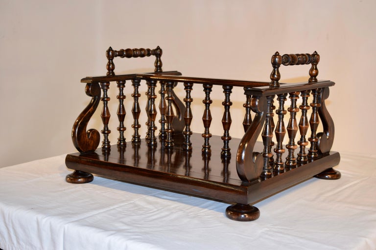 19th century bookstand from England made from rosewood. The handles are hand-turned along with the spindles, which terminate on the ends with lovely lyre inspired shaped pieces. The piece is resting on hand-turned feet.