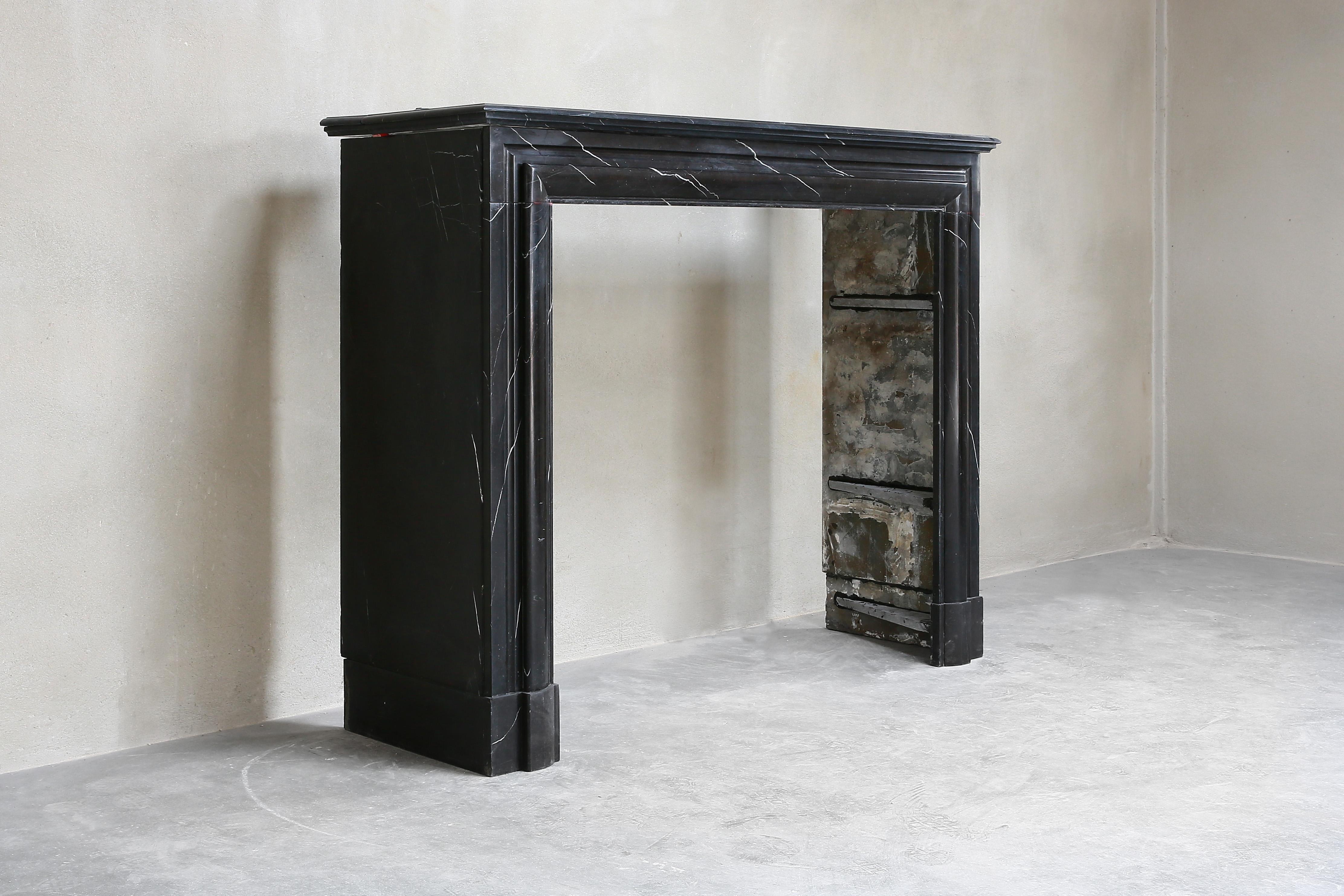 Beautiful antique fireplace made of black marble. This black marble type is called Nero Marquina and has a beautiful black color with light veins. A unique fireplace, because it is a natural product and every natural product is different. This