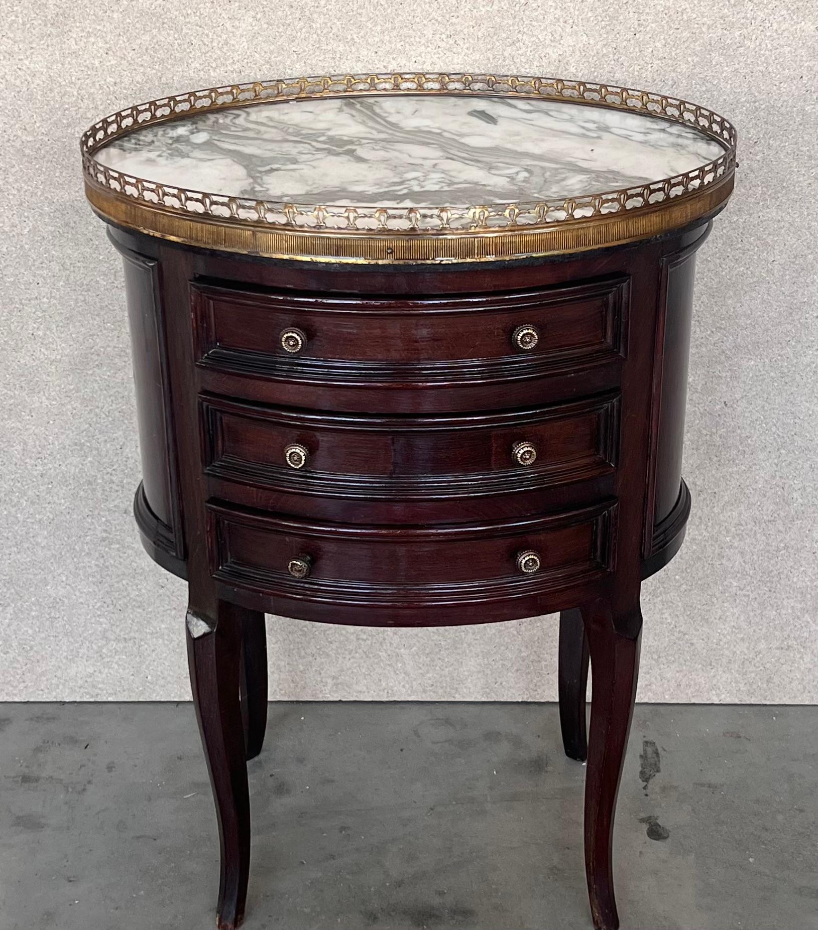 French Louis XVI style side table or nightstand topped with marquetry top, fluted legs finished with golden bronze clogs. Three dovetailed small drawers with brass details.

 