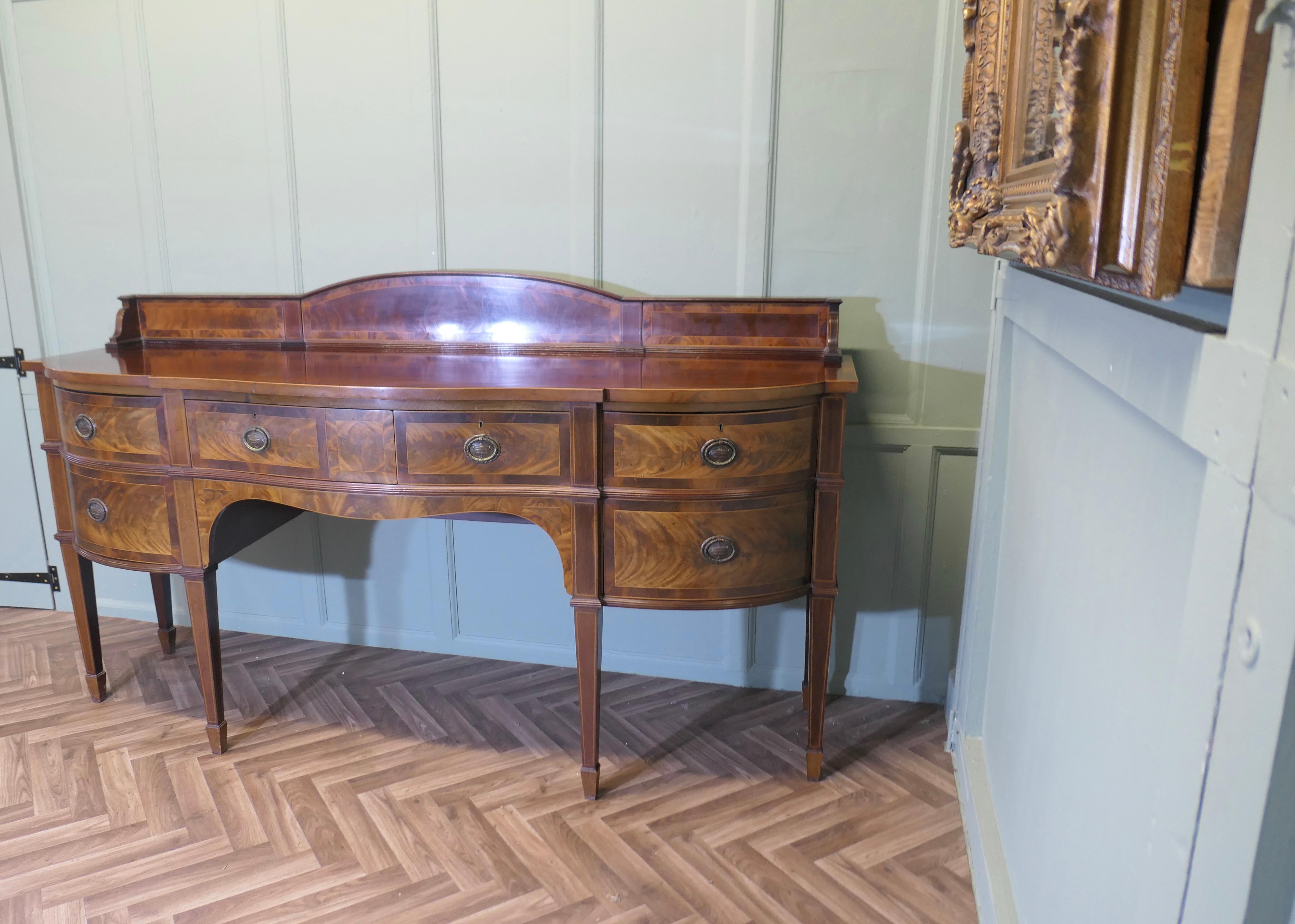 19th Century Bow Front Dresser 

This is a lovely old piece, with oval ring pull handles and charming decorative veneers to the arched back gallery
The sideboard has tapering legs, a central long and a cutlery drawer, at one side a shelved cupboard