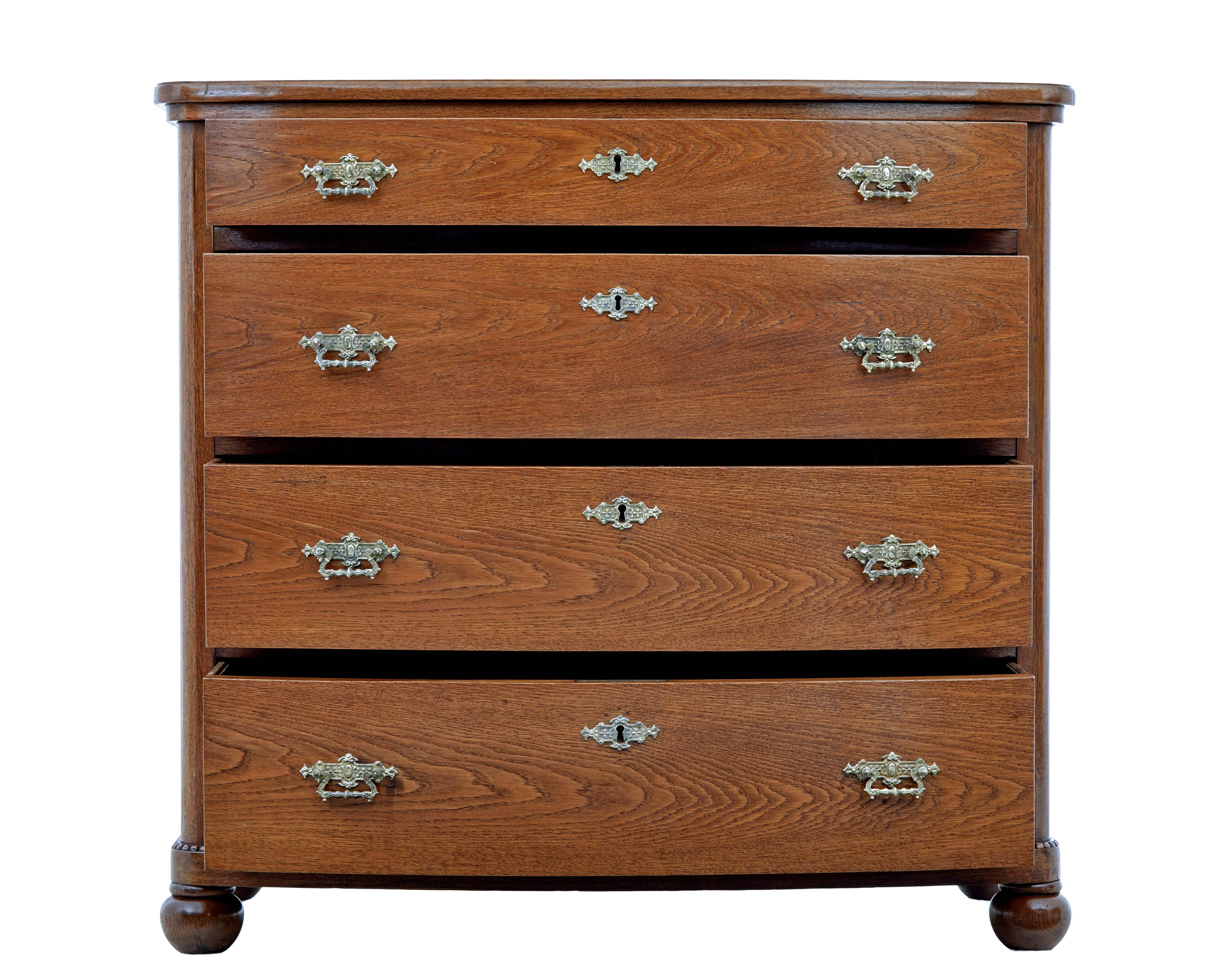 19th century bowfront oak chest of drawers circa 1880.

Fine quality robust chest of drawers made in oak.  Bowfront shaped and fitted with 4 drawers and original ornate brass handles and escutheons.

Plain oak top with moulded edge, below which a