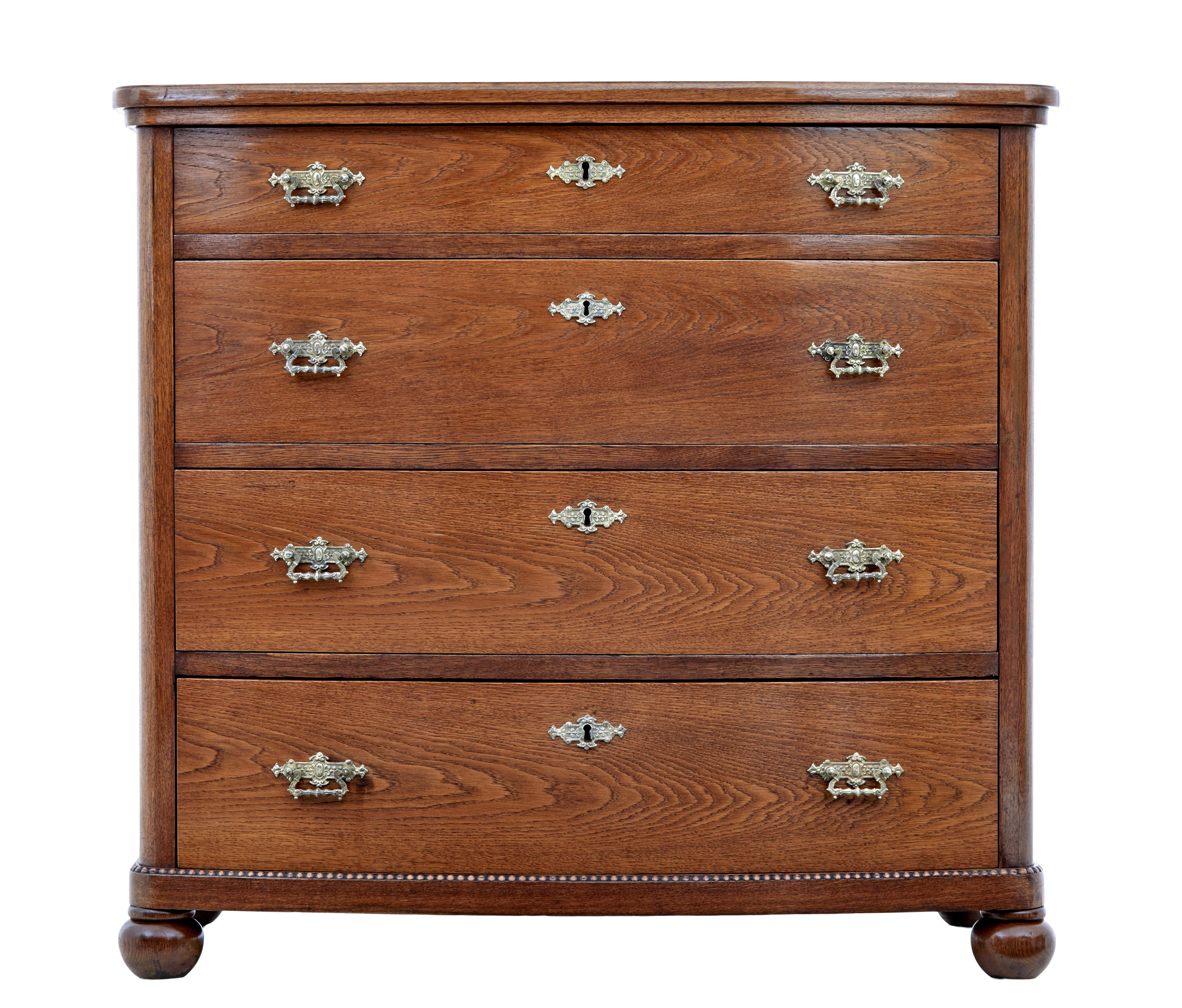 19th century bowfront oak chest of drawers circa 1880.

Fine quality robust chest of drawers made in oak.  Bowfront shaped and fitted with 4 drawers and original ornate brass handles and escutheons.

Plain oak top with moulded edge, below which a