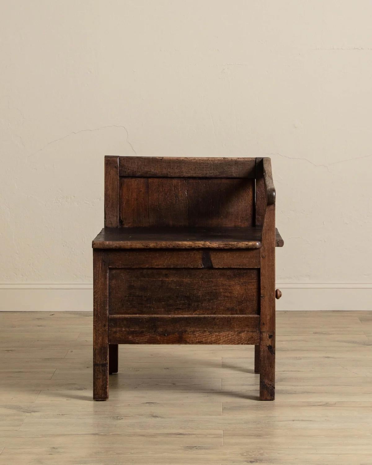 Cette rare chaise à caisson du XIXe siècle présente une silhouette vraiment distinctive, définie par son design d'angle unique et son caractère usé par le temps. Fabriqué avec art et praticité, il comporte une porte de placard qui s'ouvre pour