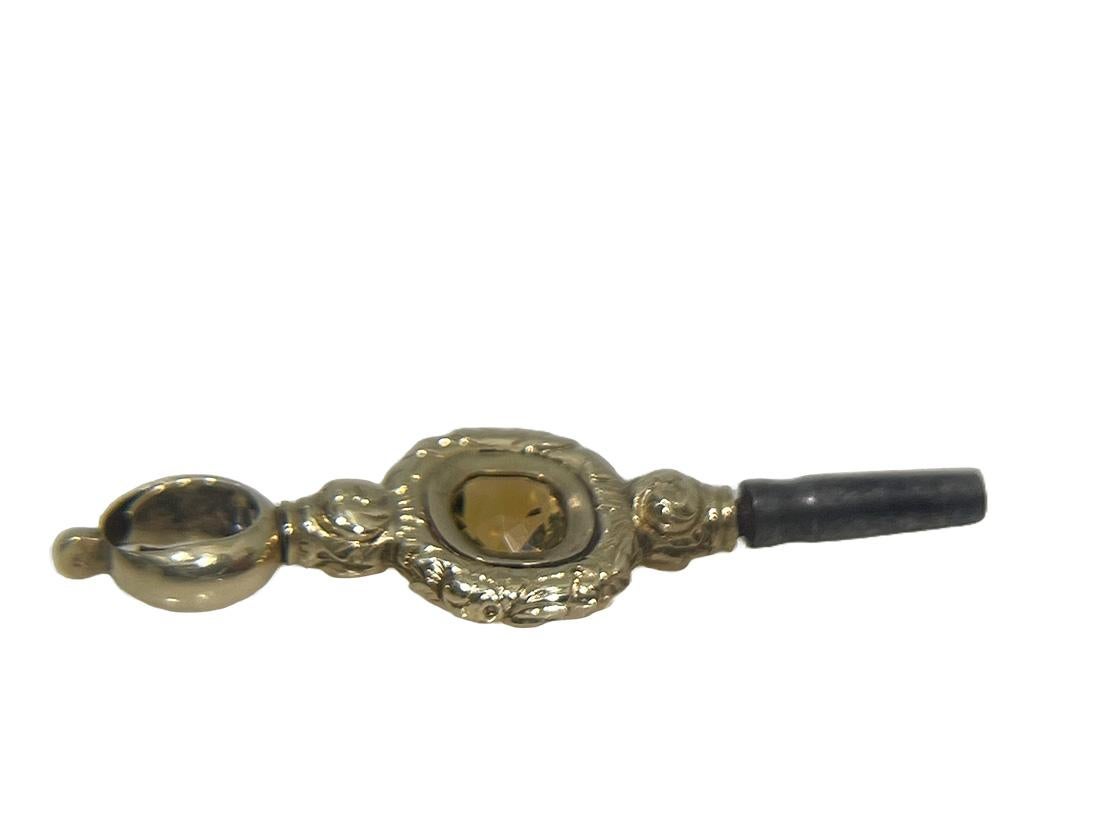 19th century Brass and Gold Watch-Key with Citrine stone

A brass watch key , gold-plated with yellow Citrine stone. The Citrine stone is cut in diamond facet shaped pattern. This gives more dimension in the light.  Decorated in relief with floral