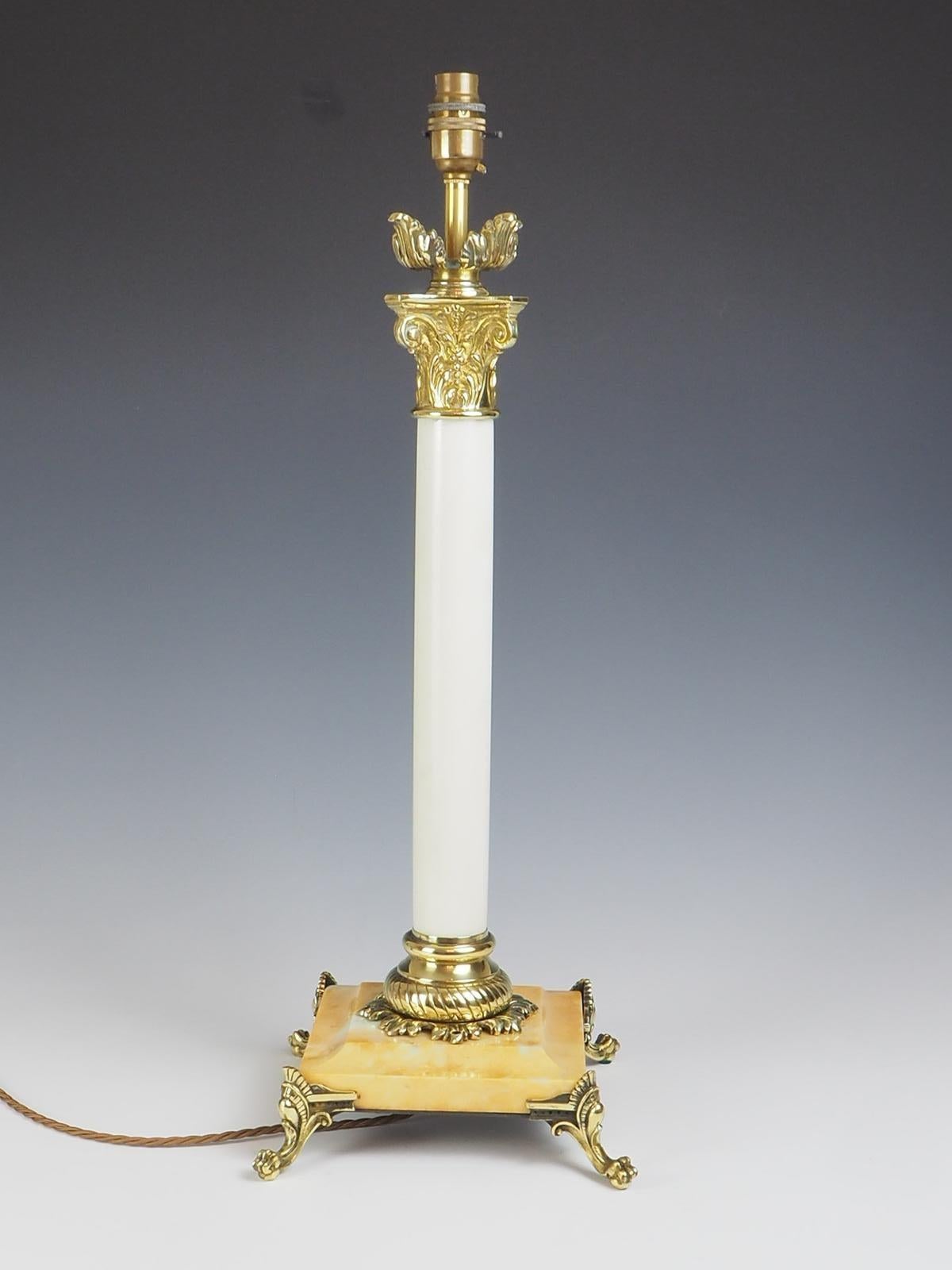 Lampe de table corinthienne en laiton et marbre du XIXe siècle, un mélange étonnant d'élégance intemporelle et d'artisanat exquis. Fabriquée avec une colonne en marbre blanc massif et une base en marbre pêche, cette lampe respire la