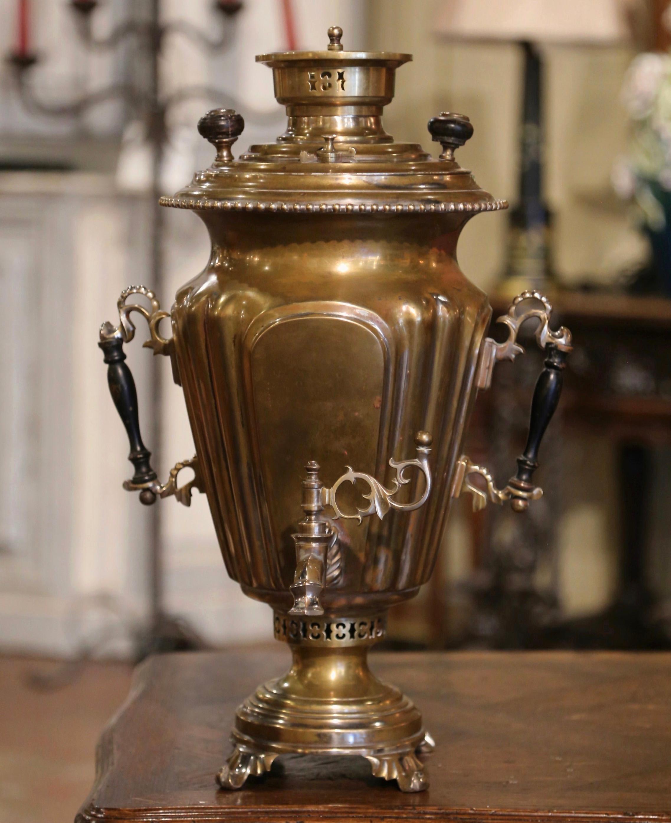 Decorate your bar, cellar or cabinet with this decorative samovar. Crafted in Russia circa 1898, the tea drinking device stands tall and features wooden handles and easy to use spout. The antique imperial style pitcher functions by putting hot coal