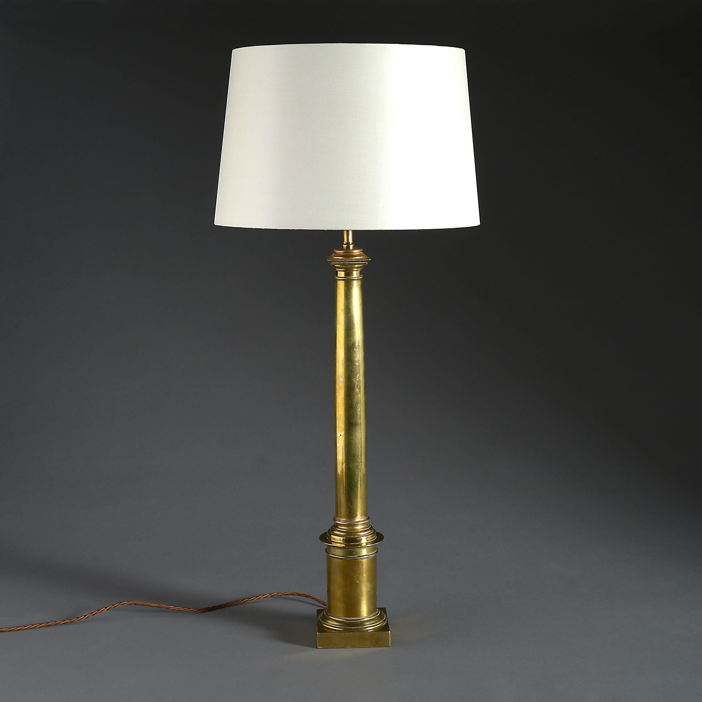 A mid-19th century brass column lamp, having doric capital and set upon a round socle base. 

Wired for electricity.