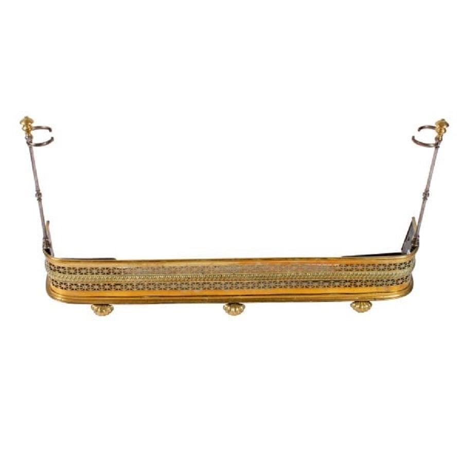 A mid 19th century pierced brass fender with brass and steel fire tools.

The fender has a brass and steel tool stand at each end which are removable.

The three fire tools consist of tongs, a poker and a shovel and are made of steel with turned