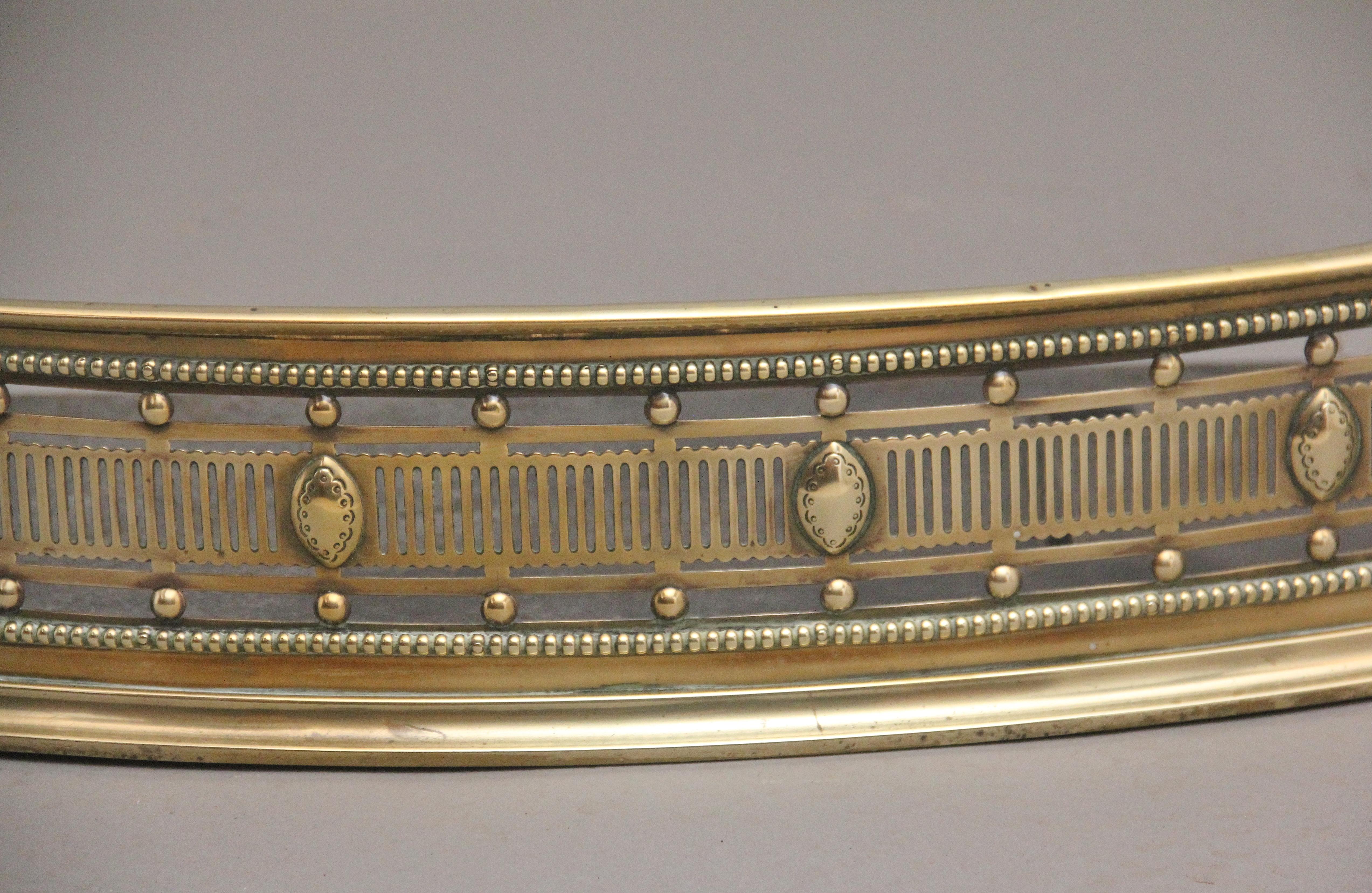 A highly decorative and very fine 19th Century brass fender of serpentine form, consisting of a wonderfully pierced frieze with stylised oval motifs, with fine beading above and below the frieze, supported on a platform base.  Circa 1850.
