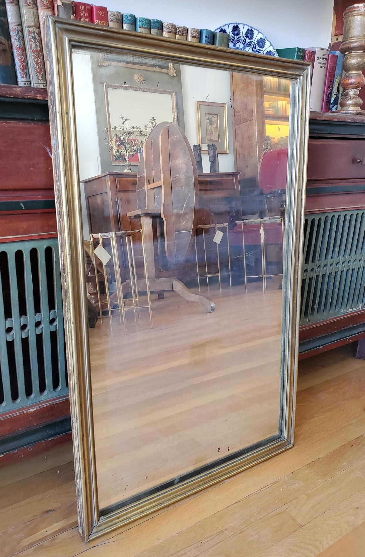 19th Century French provincial bistro mirror. 
Made of brass retaining the original mirror plate. 
Paris, circa 1870.
Measures: 34.5” H, 21.5” W, 1.25