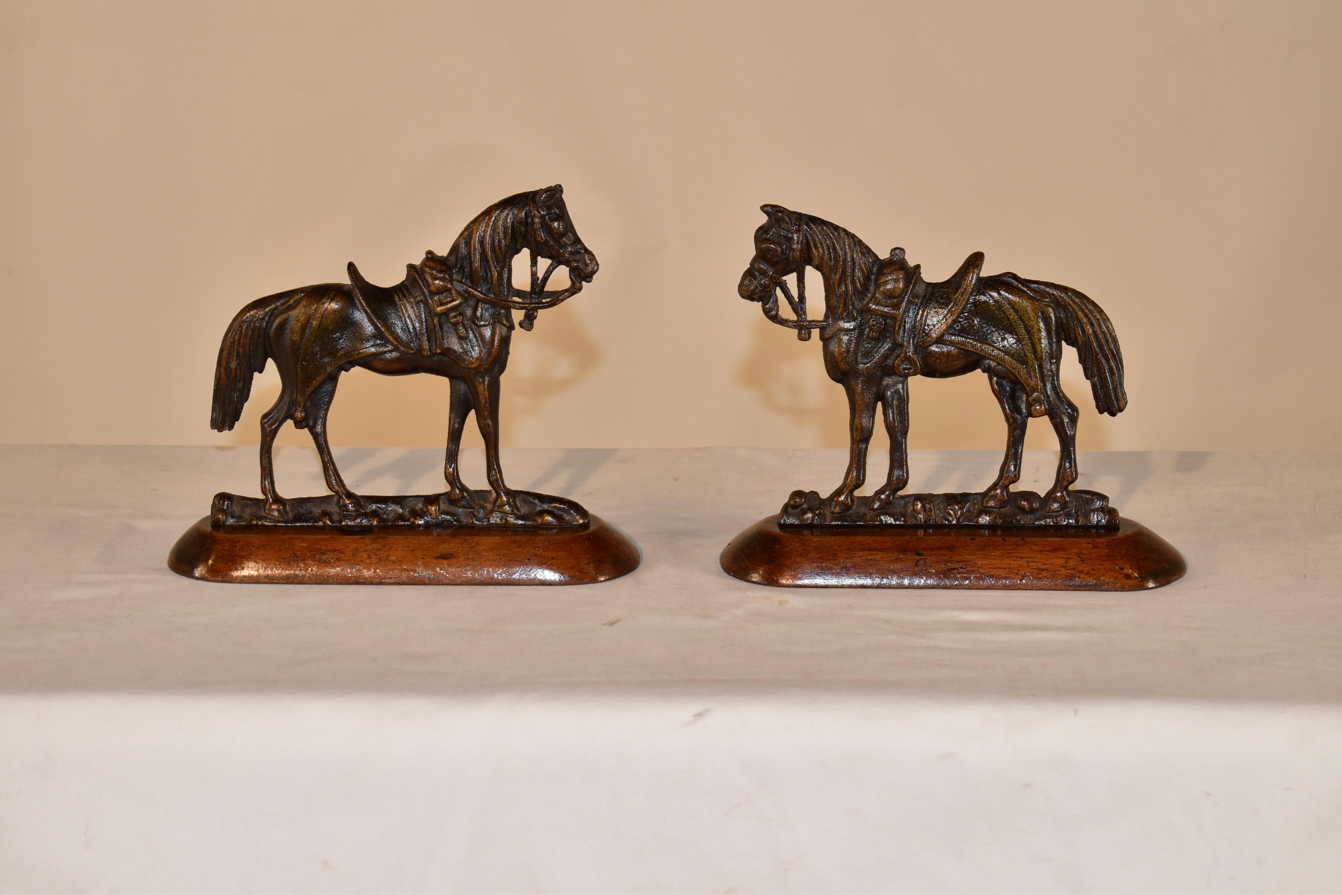 Pair of 19th century cast brass horses mounted on mahogany bases.  The horses have wonderful detail and are tacked up and ready to ride!  They would've originally been used for mantle decorations or in a shelf.  They are a lovely pair and would