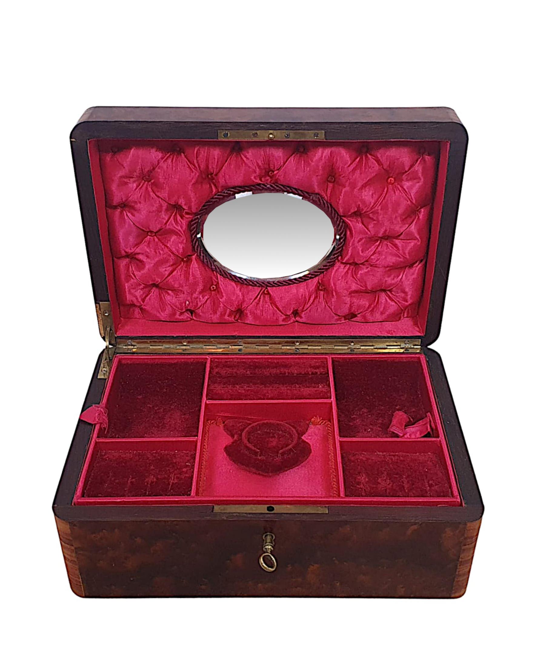A rare 19th century birds eye maple jewellery box. The moulded top of rectangular form, cross banded with kingwood and with stunning decorative brass inlay, opening to reveal a two section fitted lined interior with inset mirror.